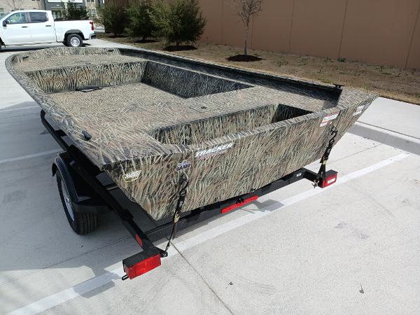 2025 Tracker GRIZZLY 1860 Utility boat on trailer, camo design, parked outdoors.