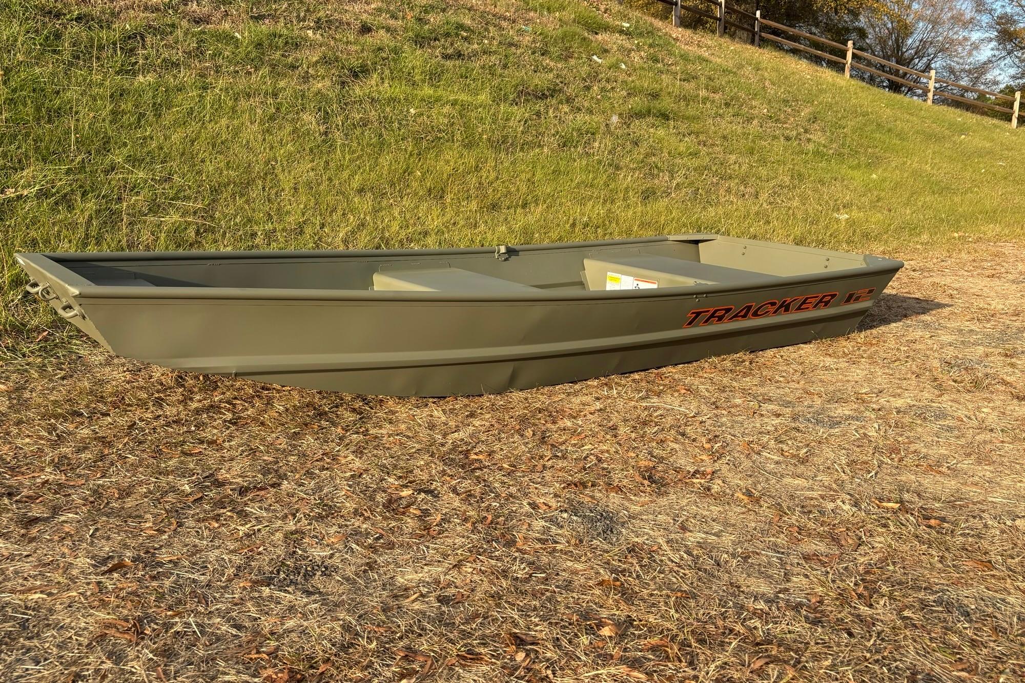 2026 Tracker Grizzly 12 Jon boat on grassy terrain, showcasing its sturdy design.