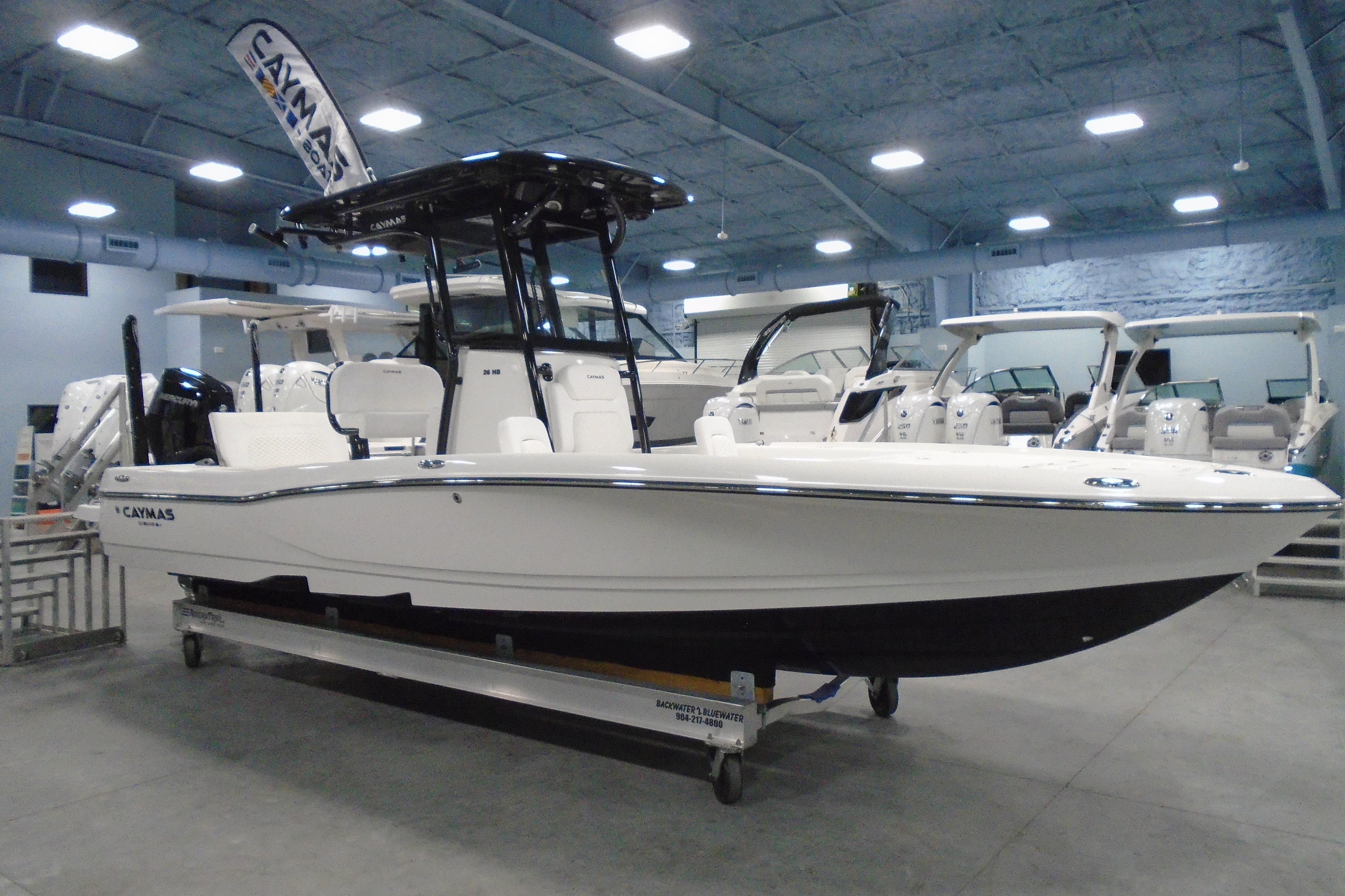 2026 Caymas 26 HB boat displayed in a showroom, featuring sleek design and modern amenities.