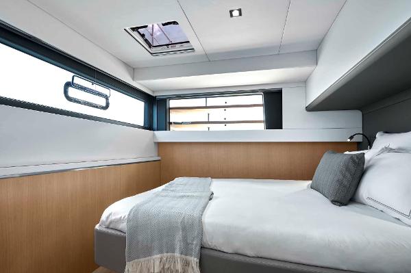 Luxurious cabin interior of 2025 Privilege Signature 580 yacht, featuring modern design and cozy bedding.