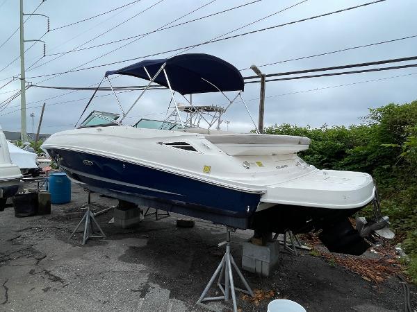 2013 Sea Ray 240 Sundeck boat with blue hull and canopy on stands.