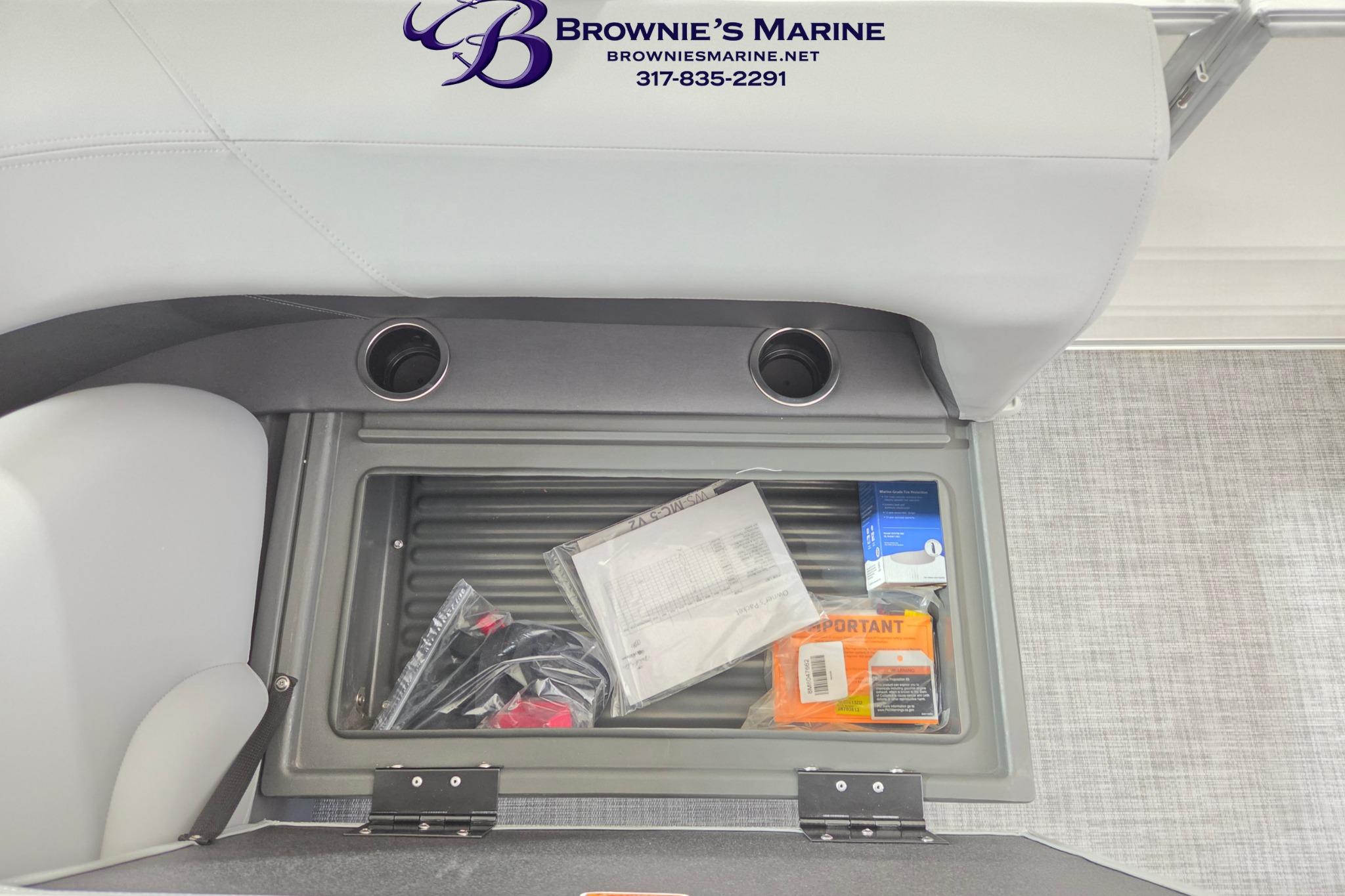 2026 Sun Tracker Party Barge 18 DLX storage compartment with accessories and documents.