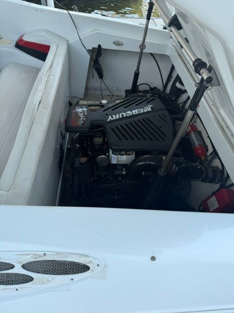 A 2002 Baja 25 Outlaw with an open engine compartment showing a Mercury engine.
