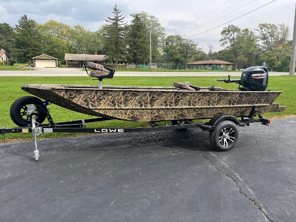 2024 Lowe Roughneck 1660 boat on trailer with camouflage design and Mercury outboard motor.