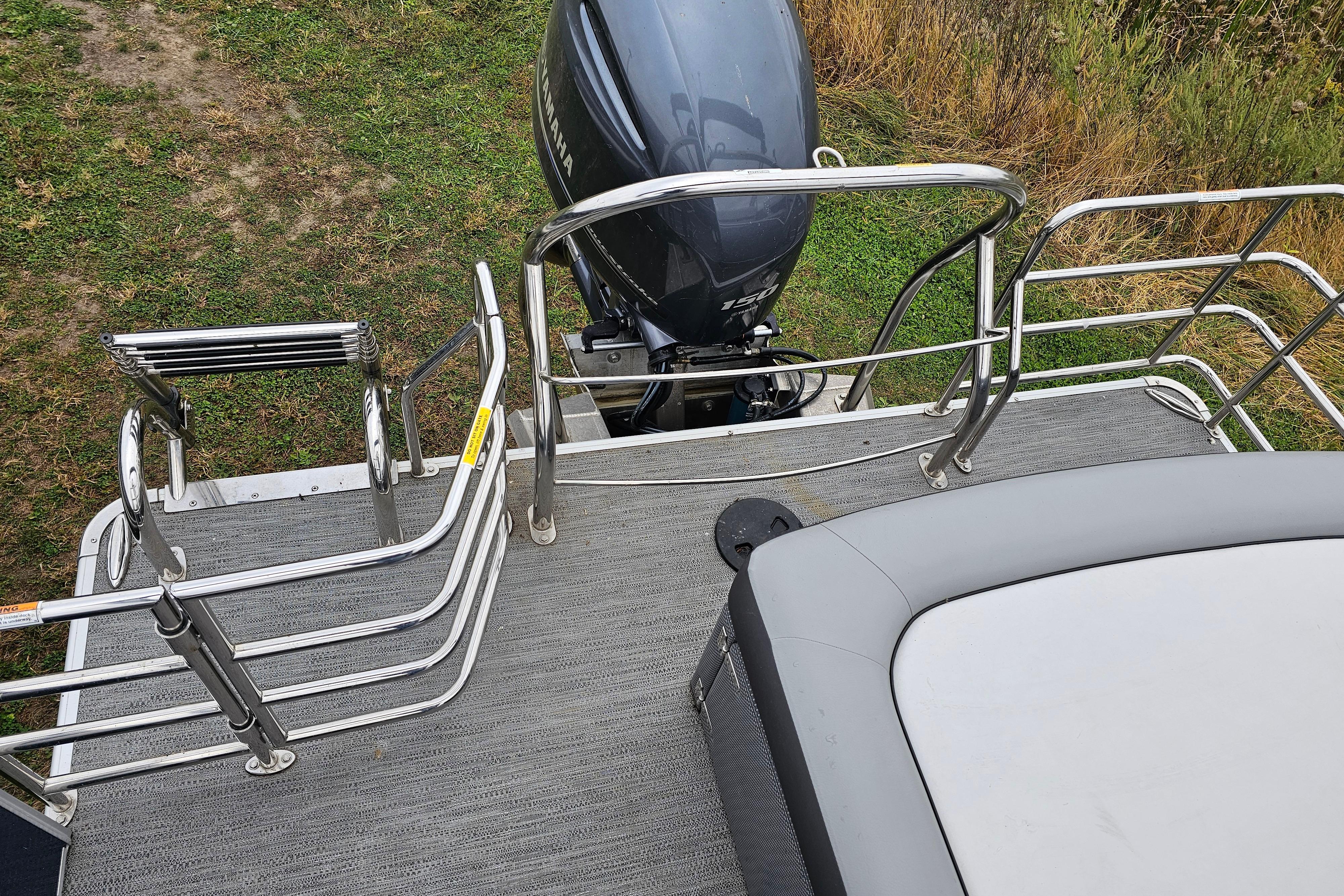 2022 Sweetwater 2286 SFL boat deck with railing and outboard motor.