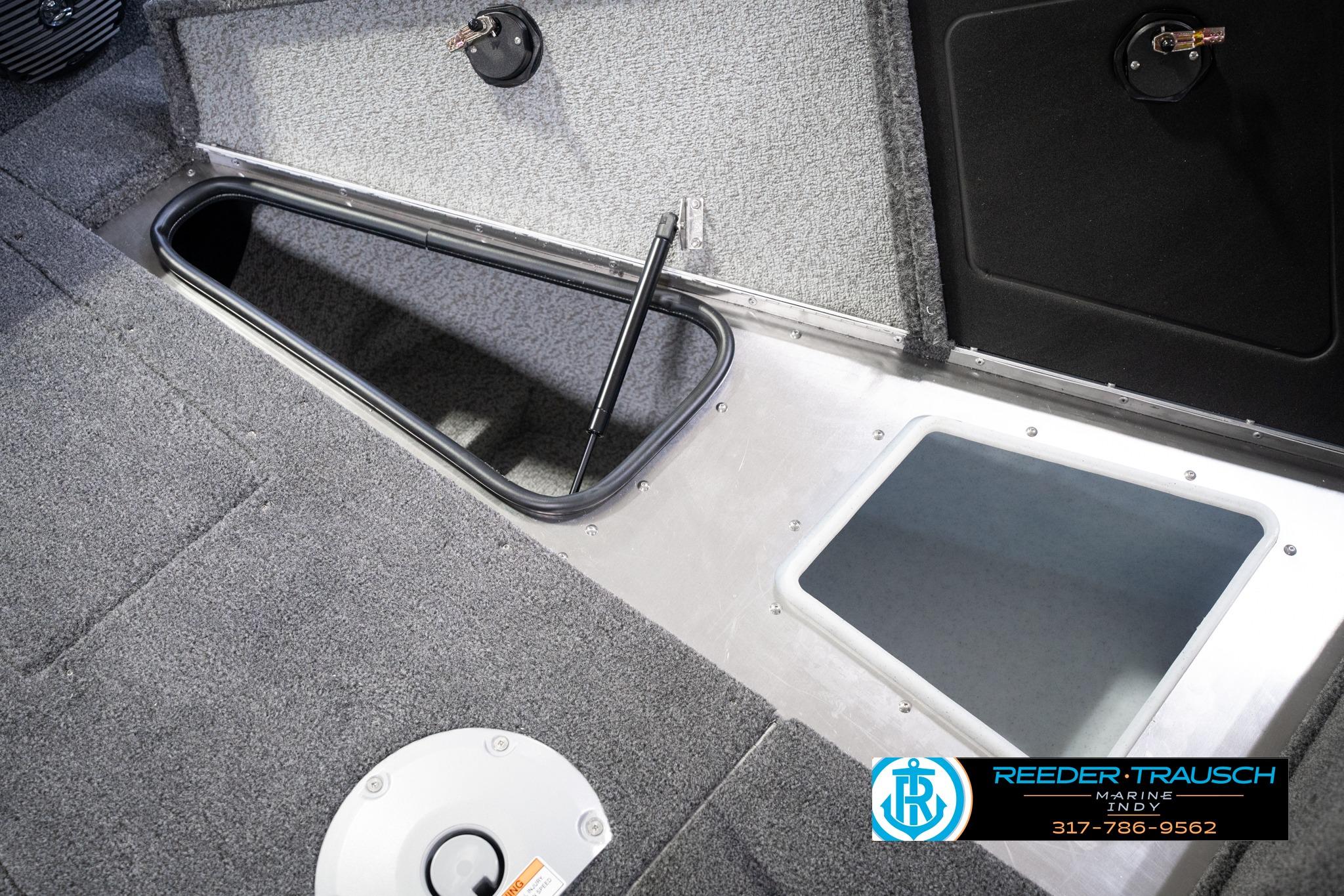 2026 Lund 1775 Impact XS SS boat interior storage compartments with carpeted flooring.
