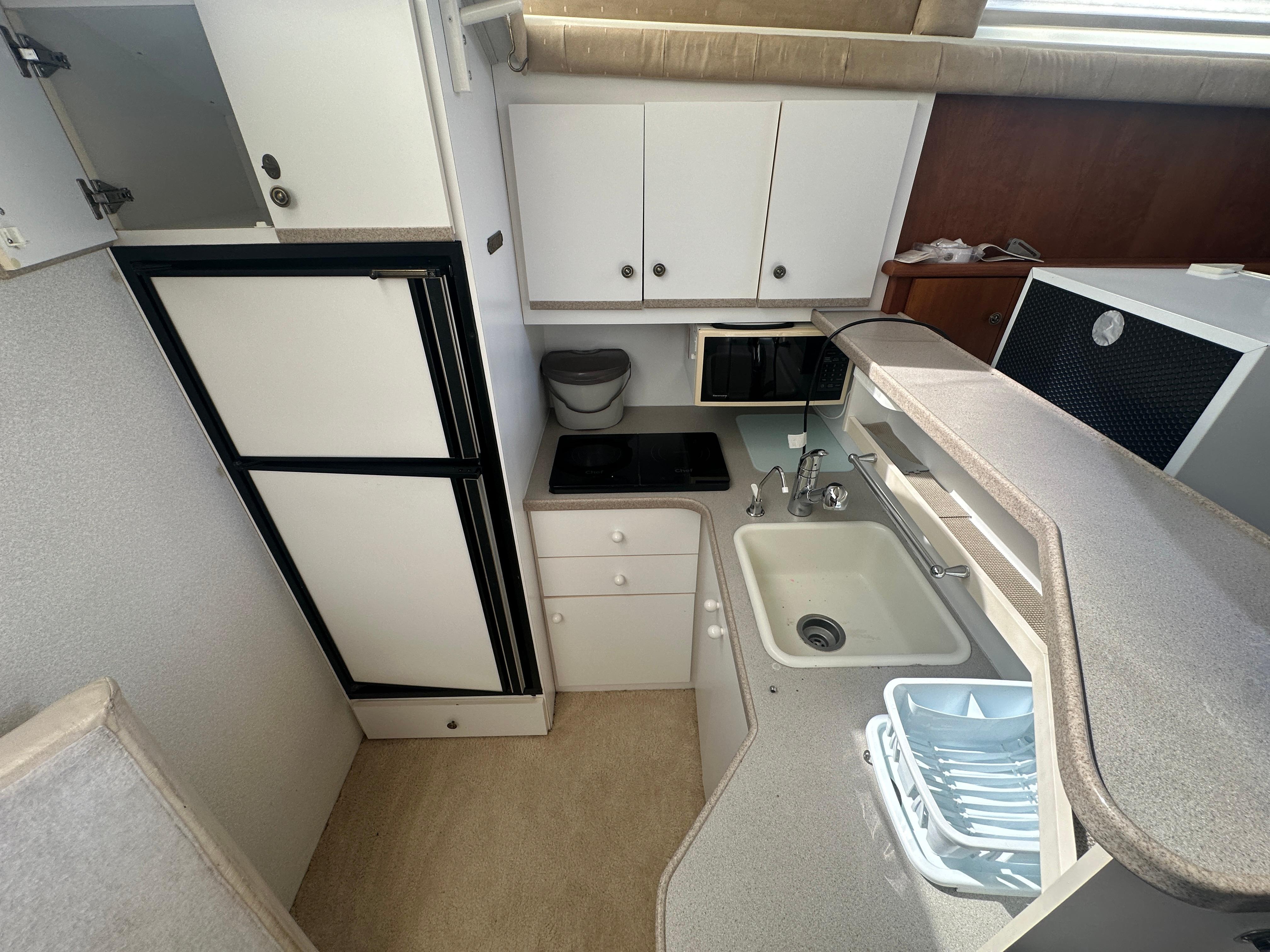 1994 Silverton 34 Aft Cabin Motor Yacht kitchen with sink, stove, and refrigerator.
