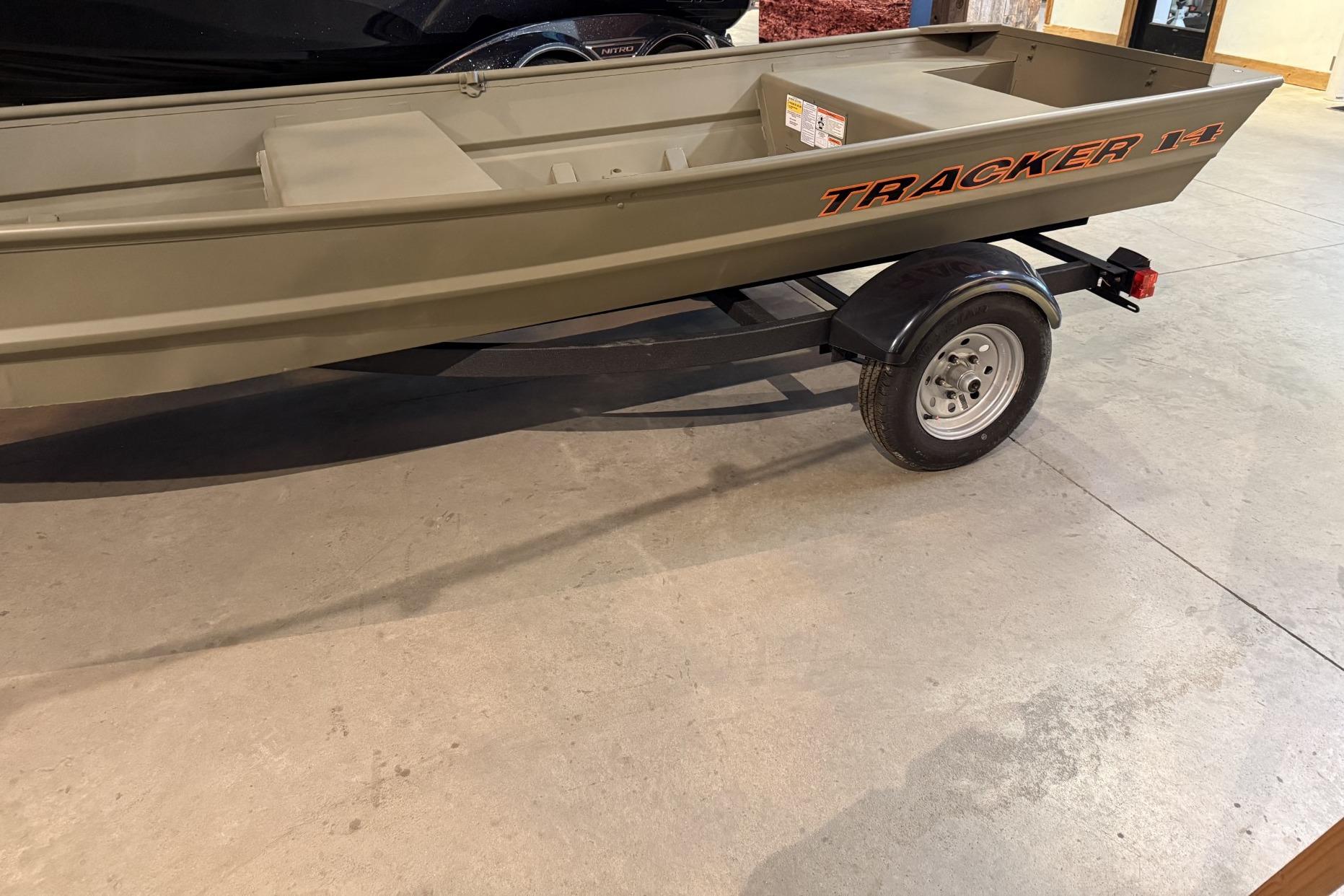 2026 Tracker Grizzly 14 Jon boat on trailer in showroom.