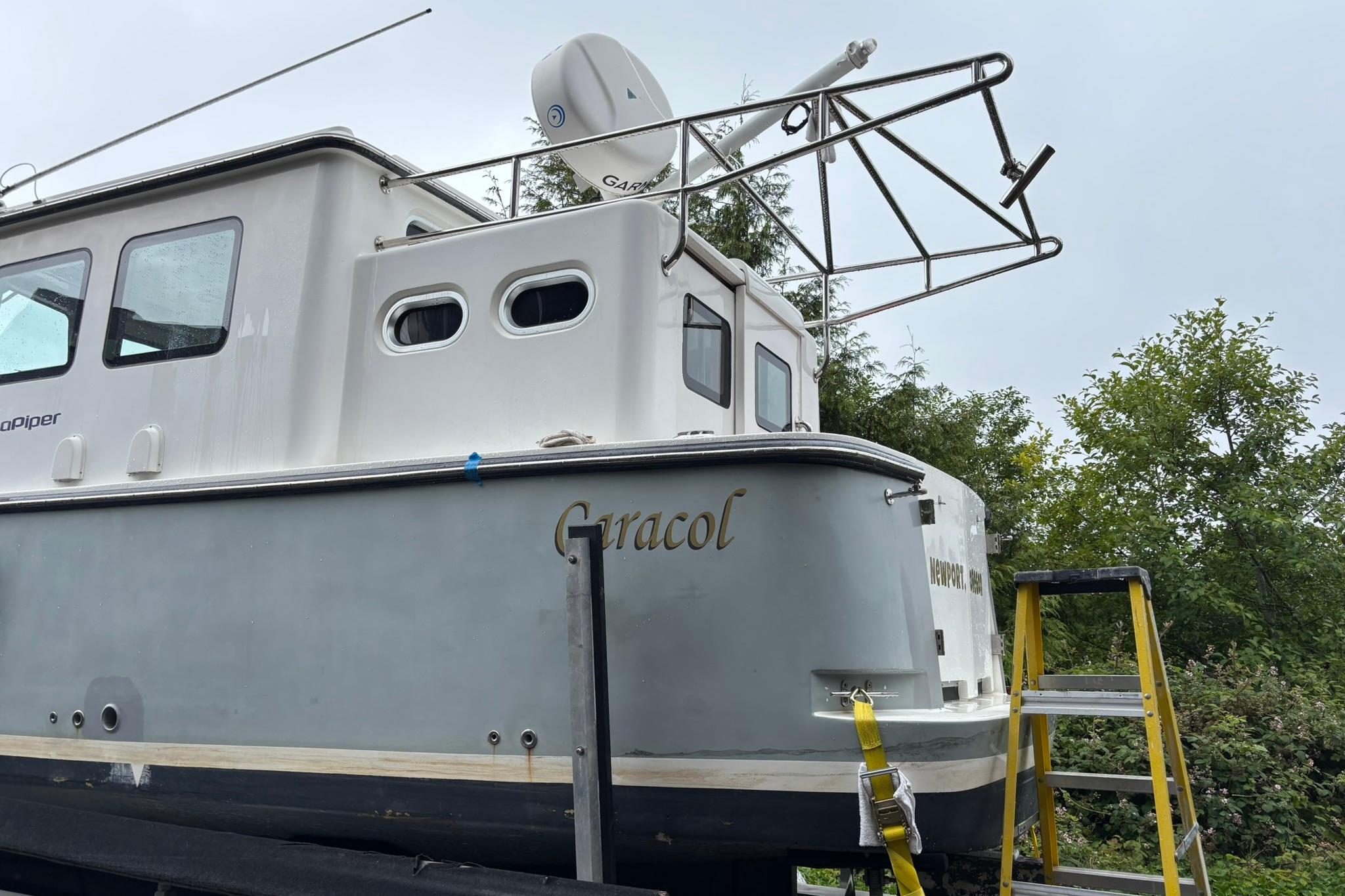 SeaPiper 35 boat from 2020 on land, with ladder and trees in the background.