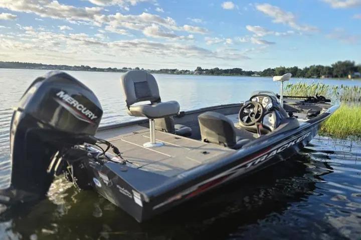 2020 Tracker Pro Team 175 TF boat on a serene lake under a blue sky.