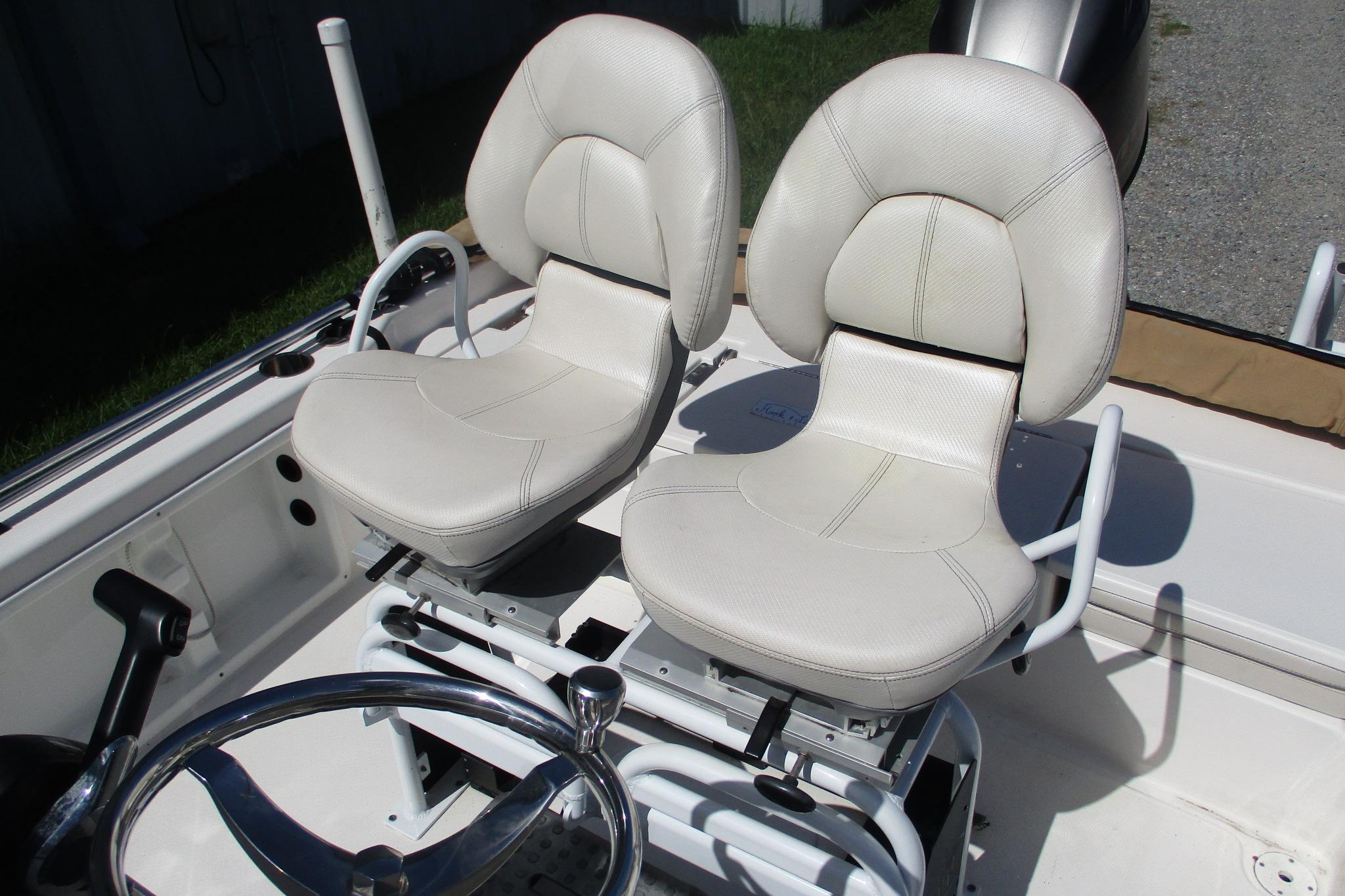 Dual white seats on 2021 Blue Wave 2000 PureBay boat, featuring a sleek steering wheel.