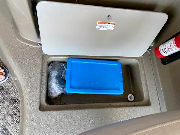 A blue container in a storage compartment on a boat.