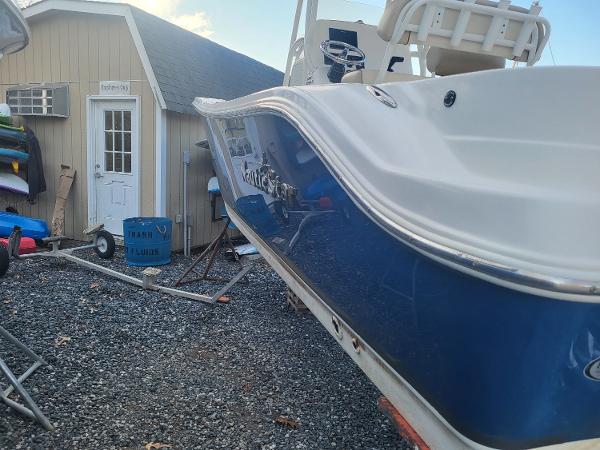 2021 NauticStar 2302 Legacy boat in a yard near a shed.