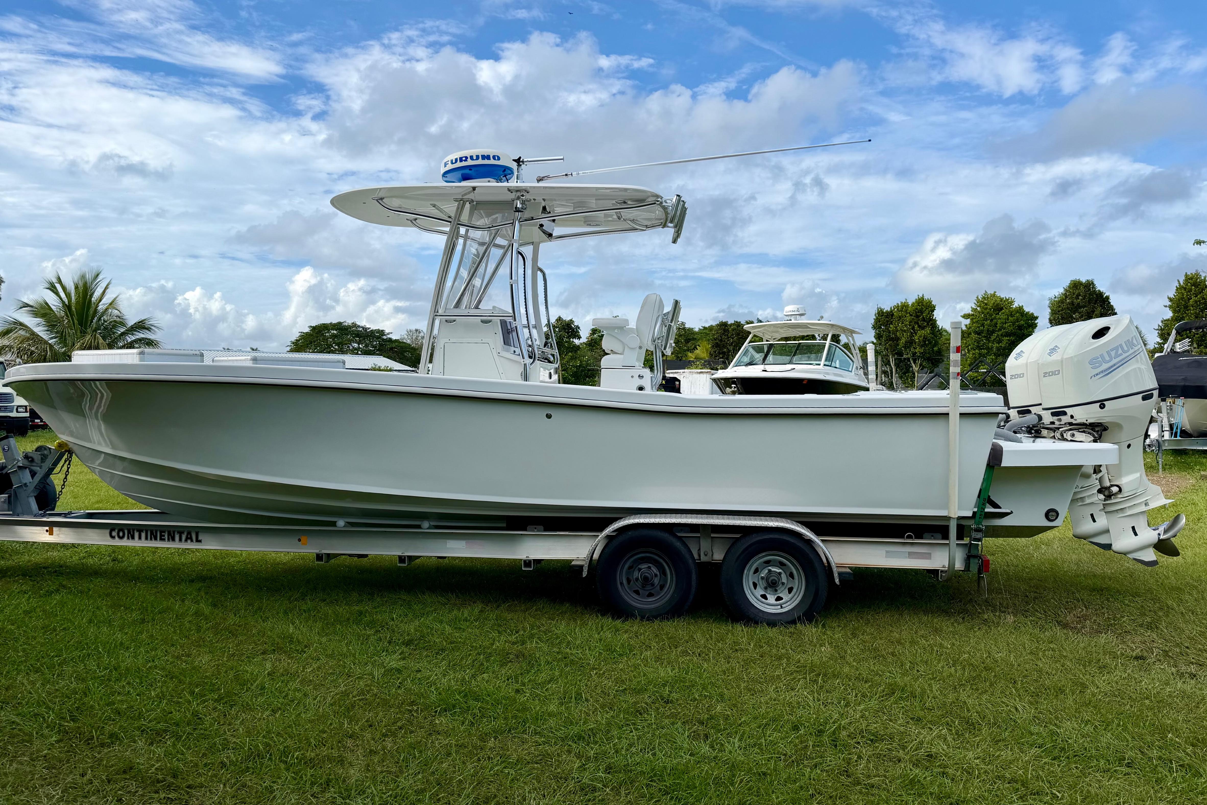 2025 Ocean Master 296 Center Console boat on trailer, parked on grass under blue sky.