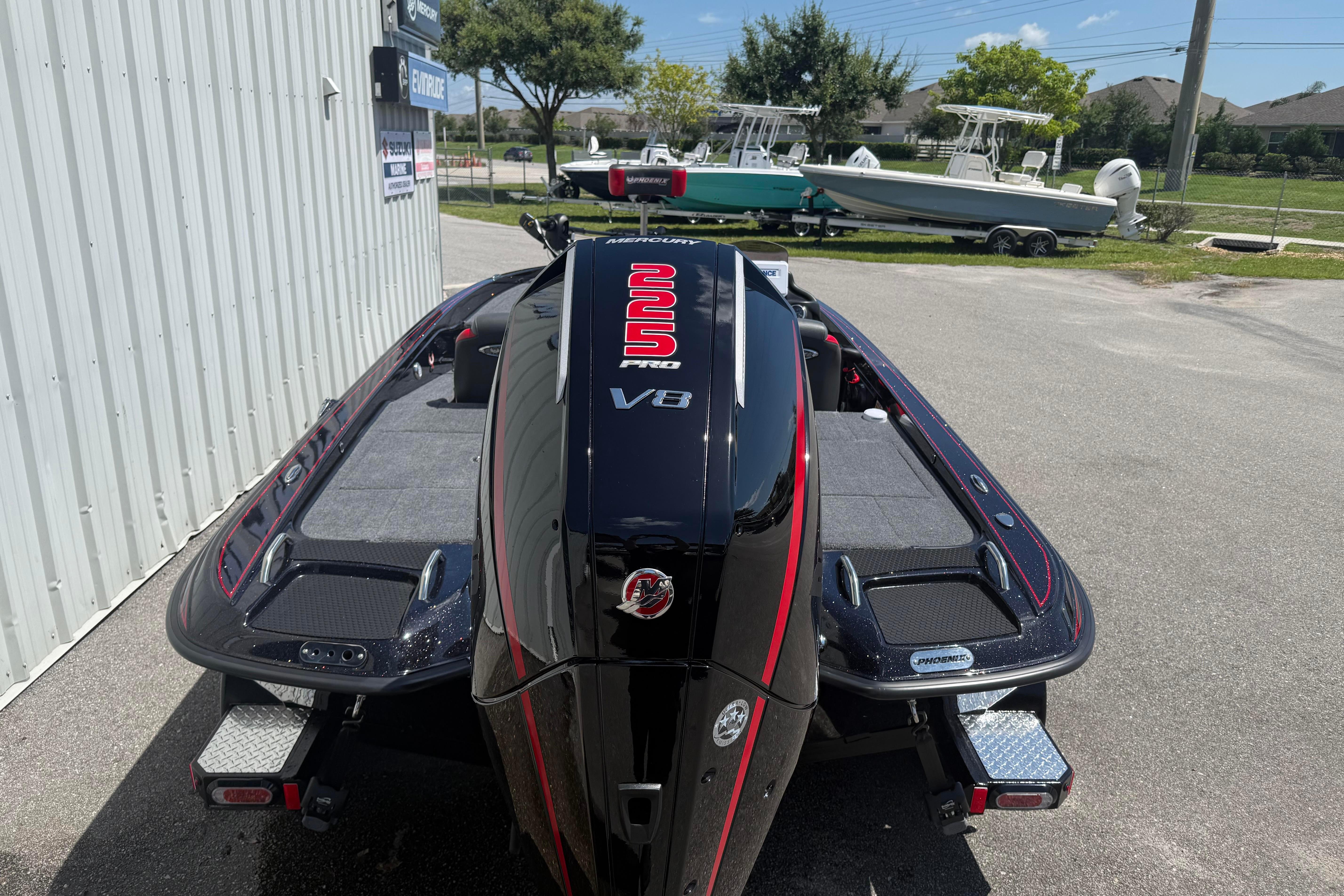 Phoenix 919 ZXL 2027 boat with V8 engine, parked outdoors near other boats.