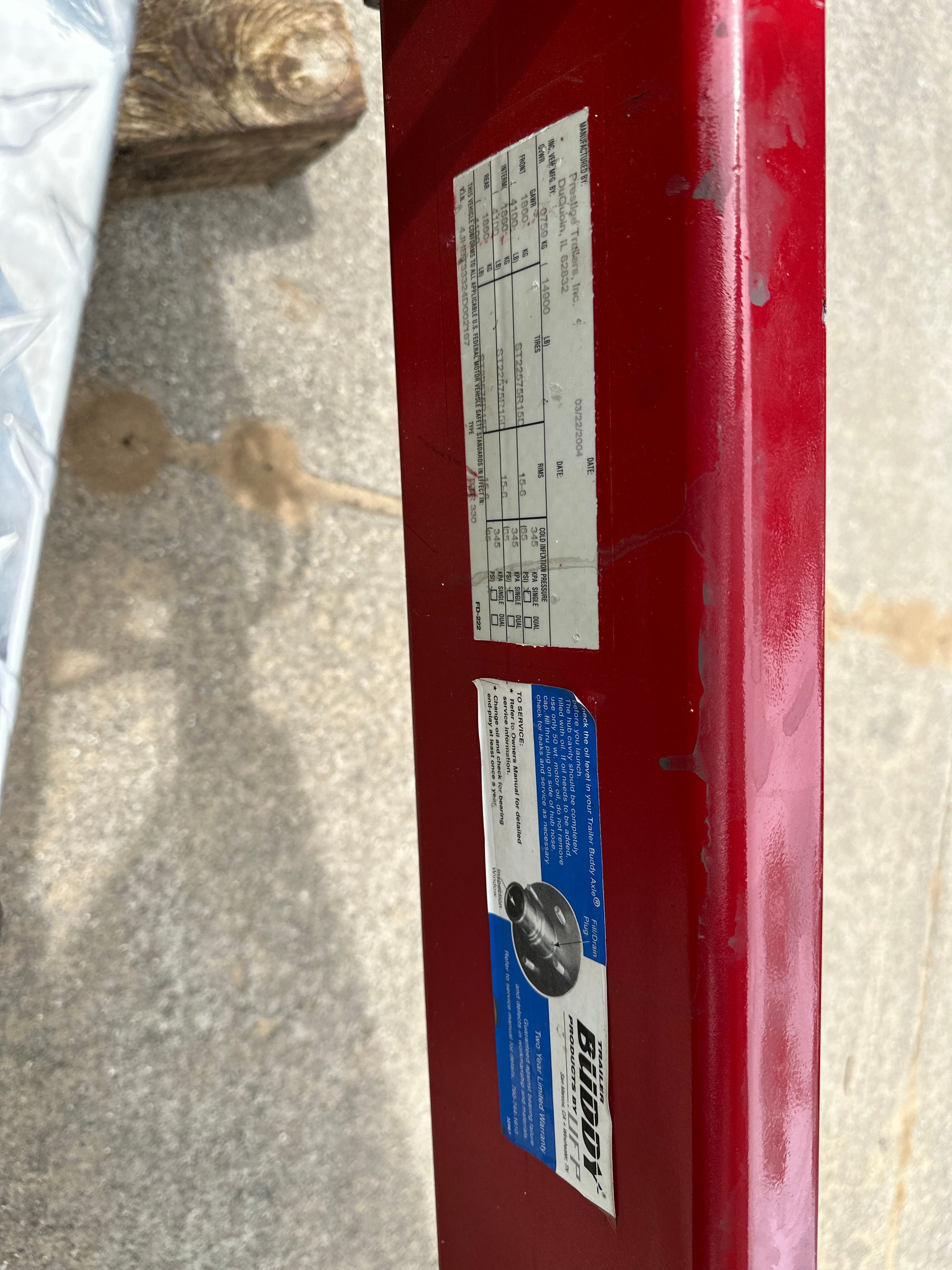 Close-up of a red boat trailer with stickers and technical information.