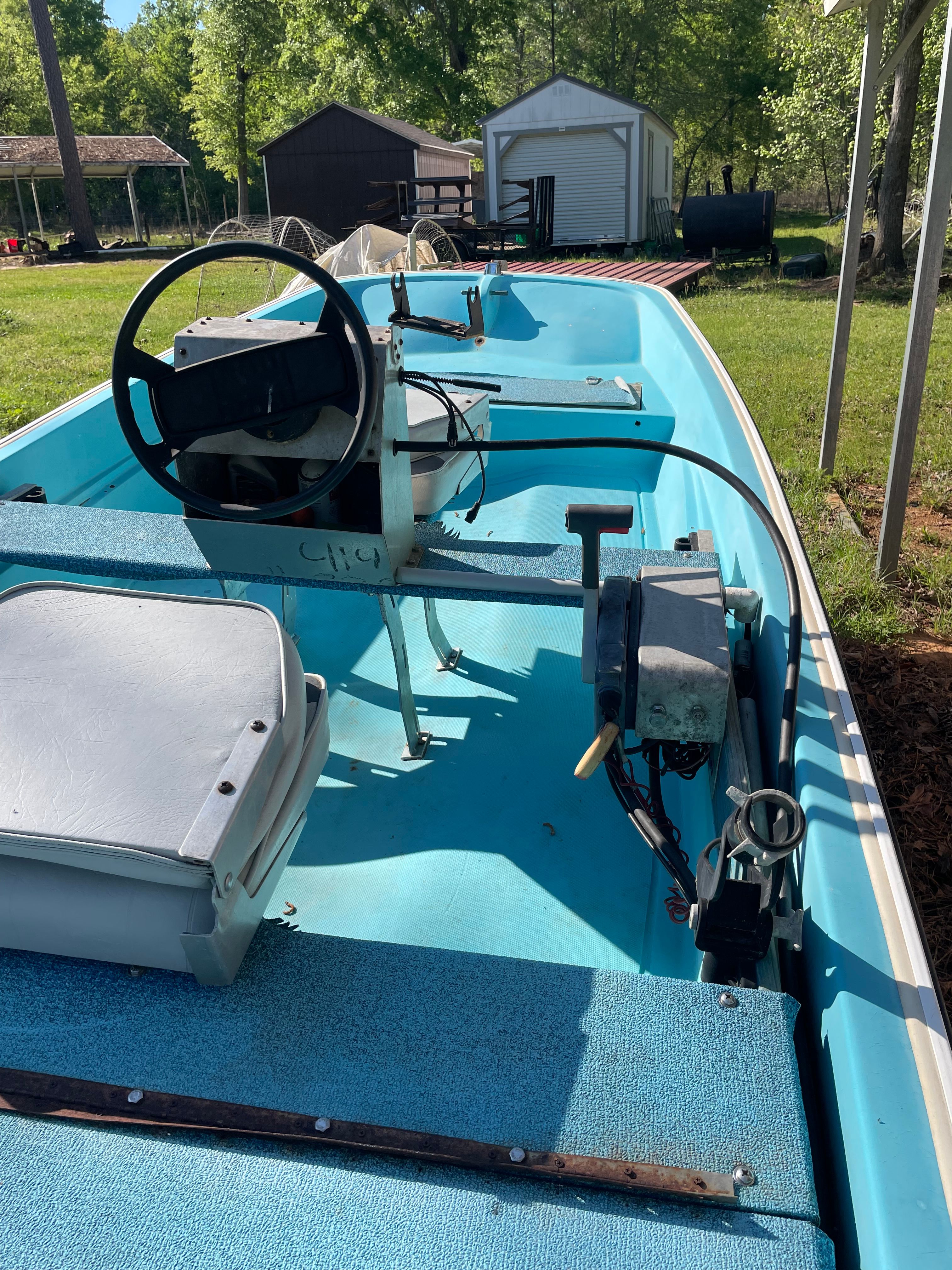 1964 Boston Whaler 13’ 6” boat in yard, blue interior.