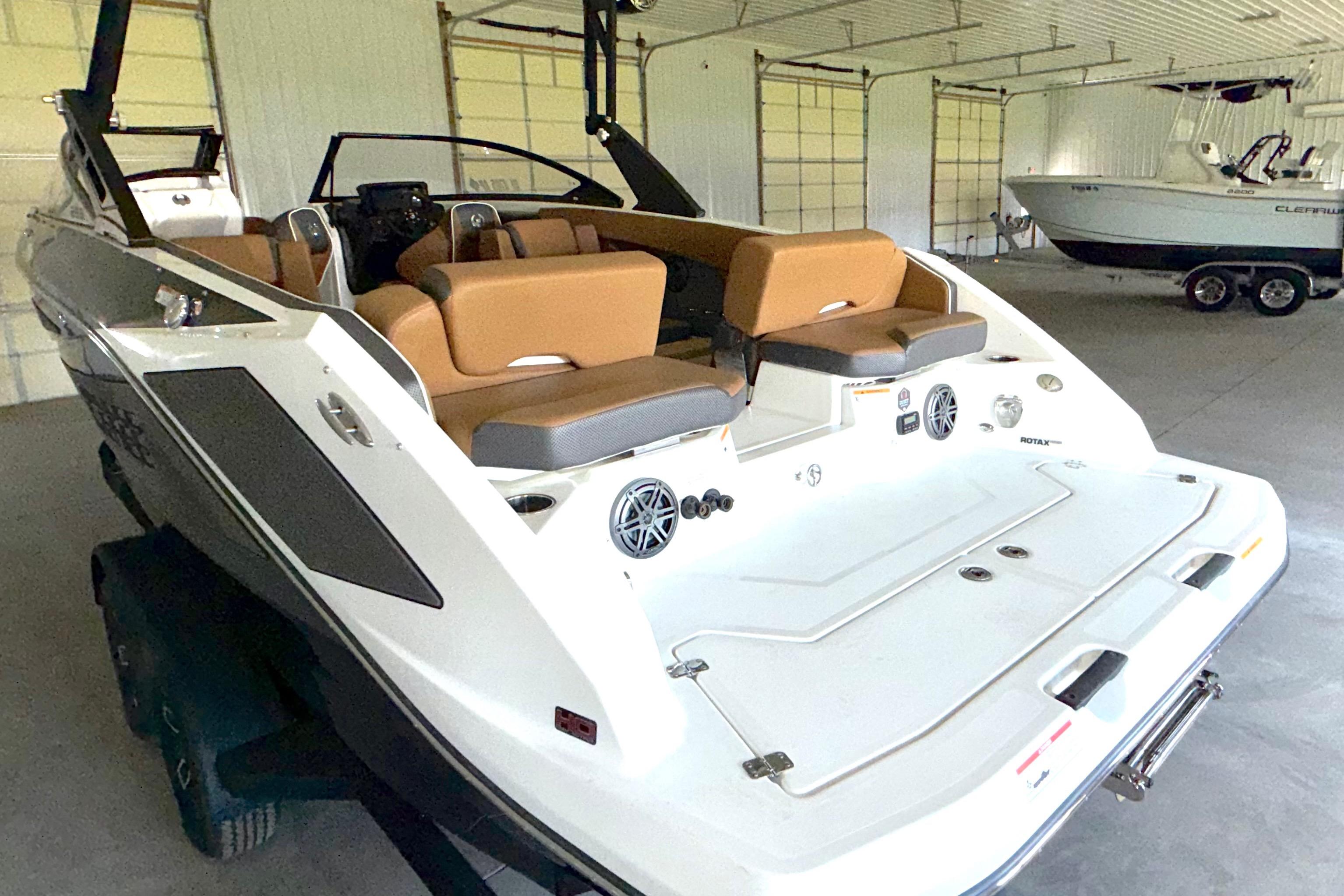 2023 Scarab 255 ID boat with tan seating in a garage setting.