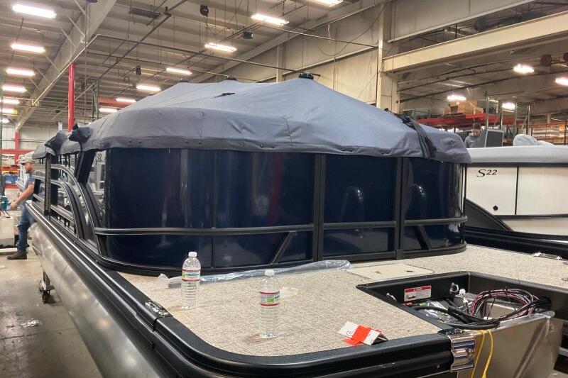 2026 Bennington 22 SSRSE pontoon boat in a factory setting, partially covered.