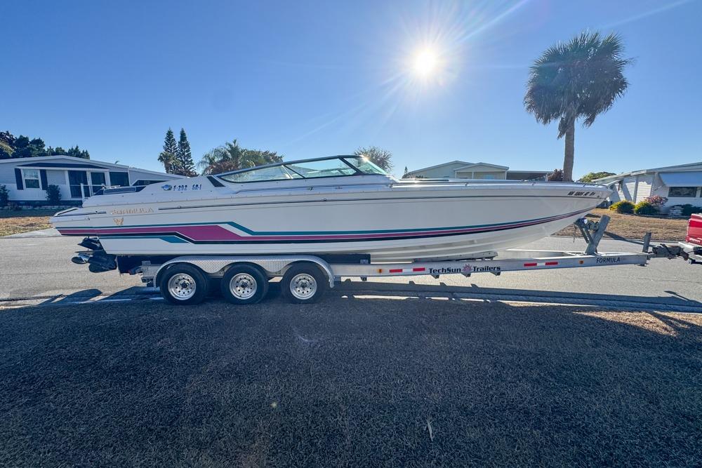 1989 Formula 292 SR-1 boat on trailer, parked in sunny residential area.