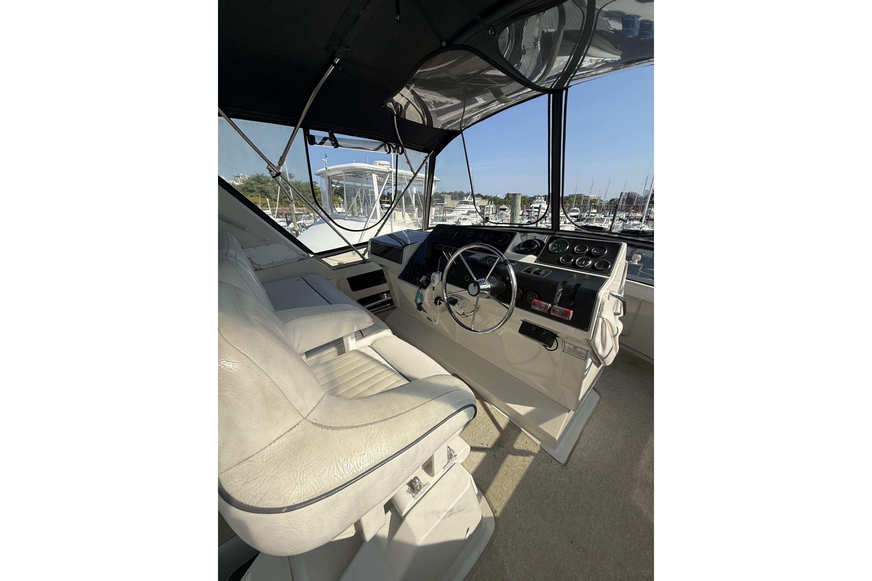 Interior helm of 1993 Carver 350 Motor Yacht with steering wheel and controls.
