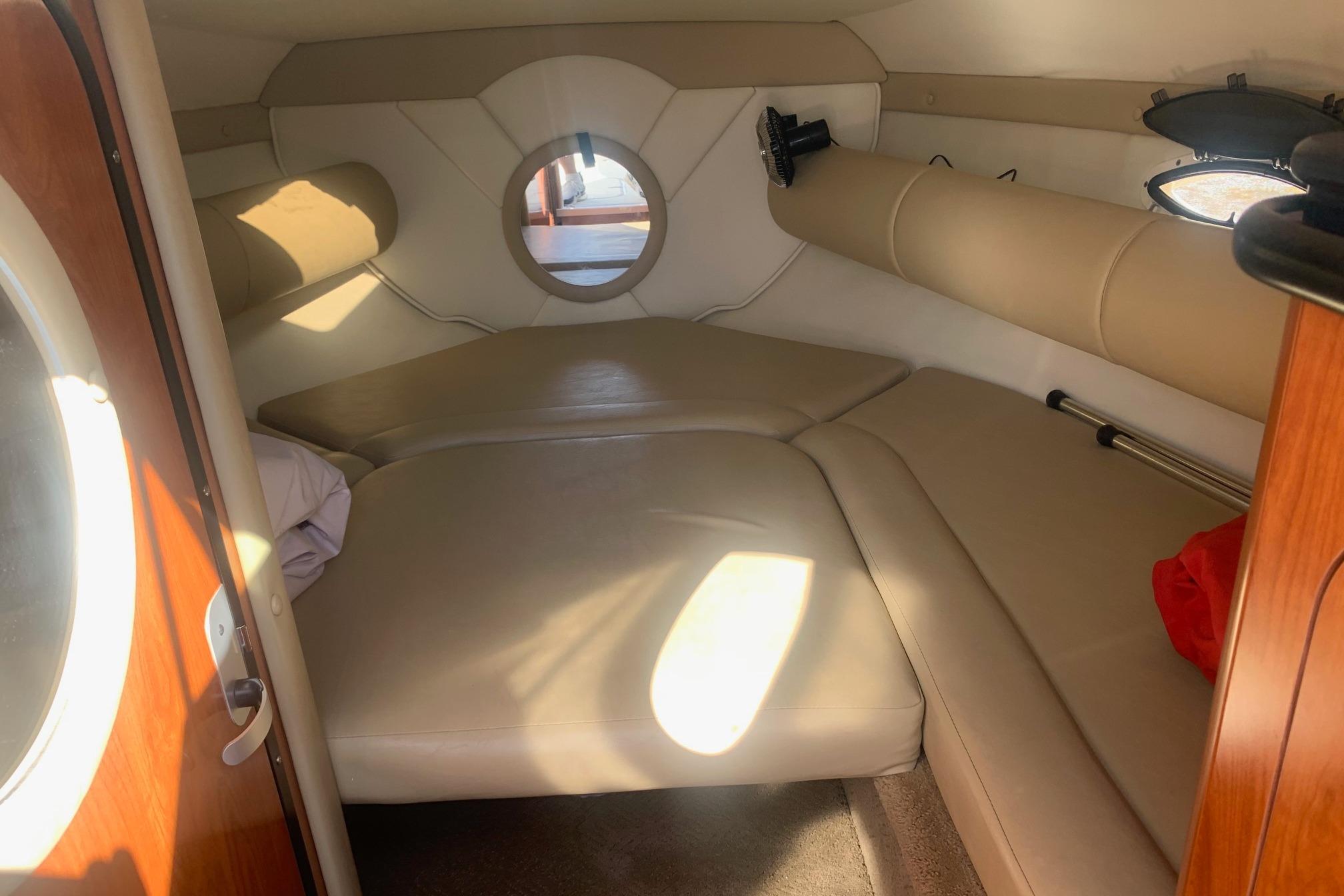 2006 Rinker 282 Captiva Cuddy cabin interior with beige seating and round window.