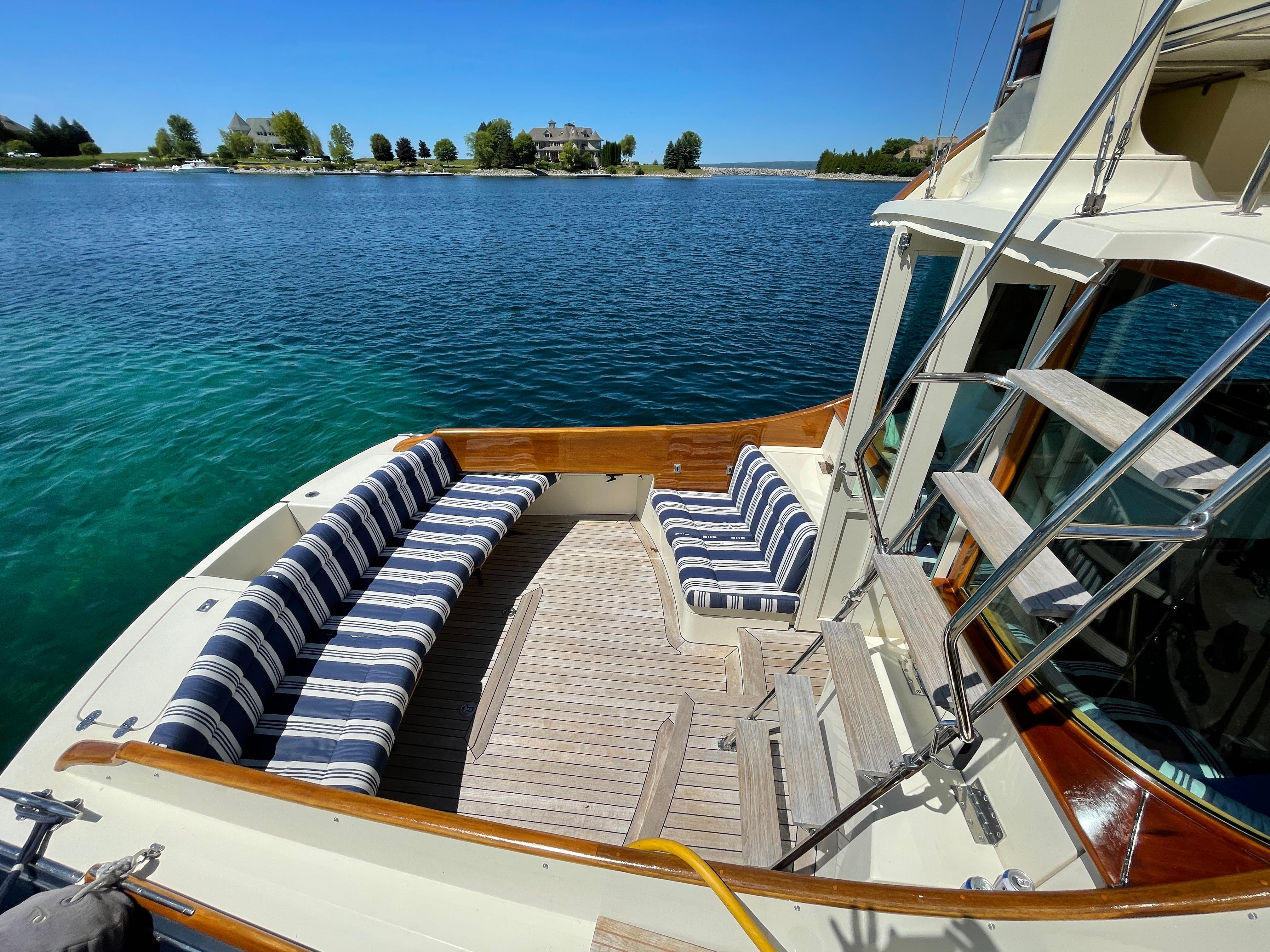 2007 Hinckley Talaria 44 Flybridge yacht with striped seating, docked on a sunny day.