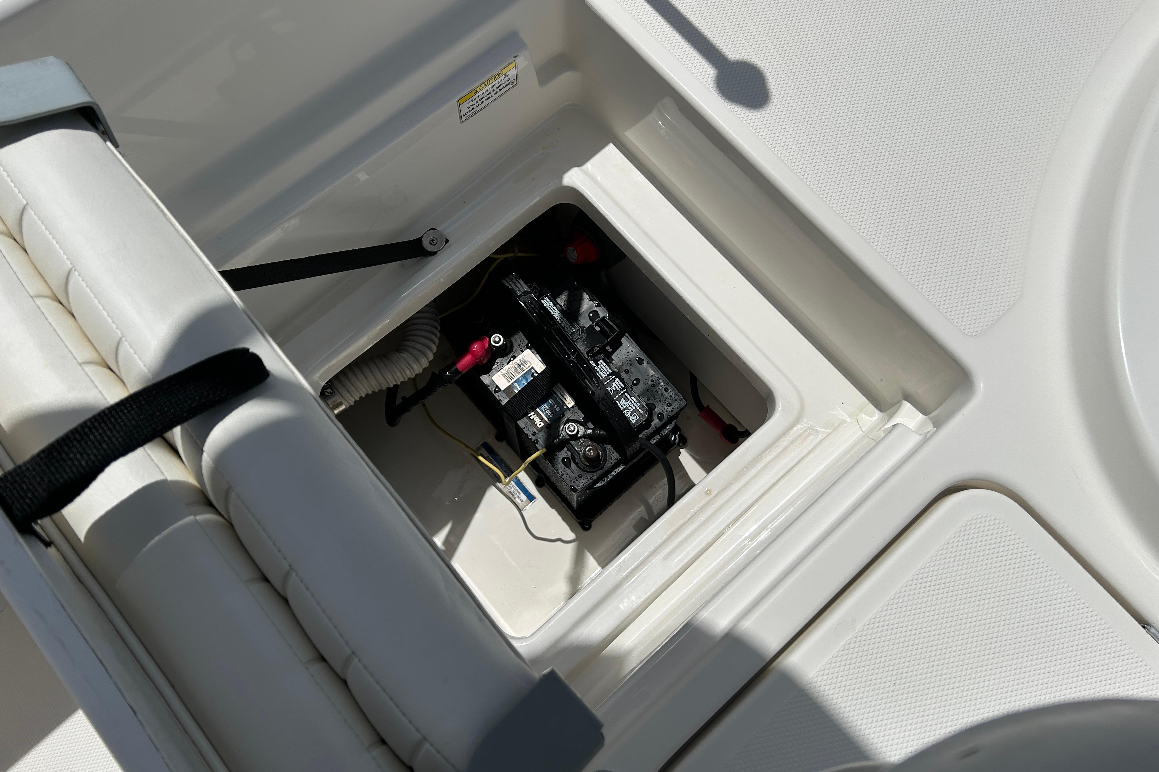 2018 Bayliner Element F16 boat battery compartment with visible wiring and secure hatch.