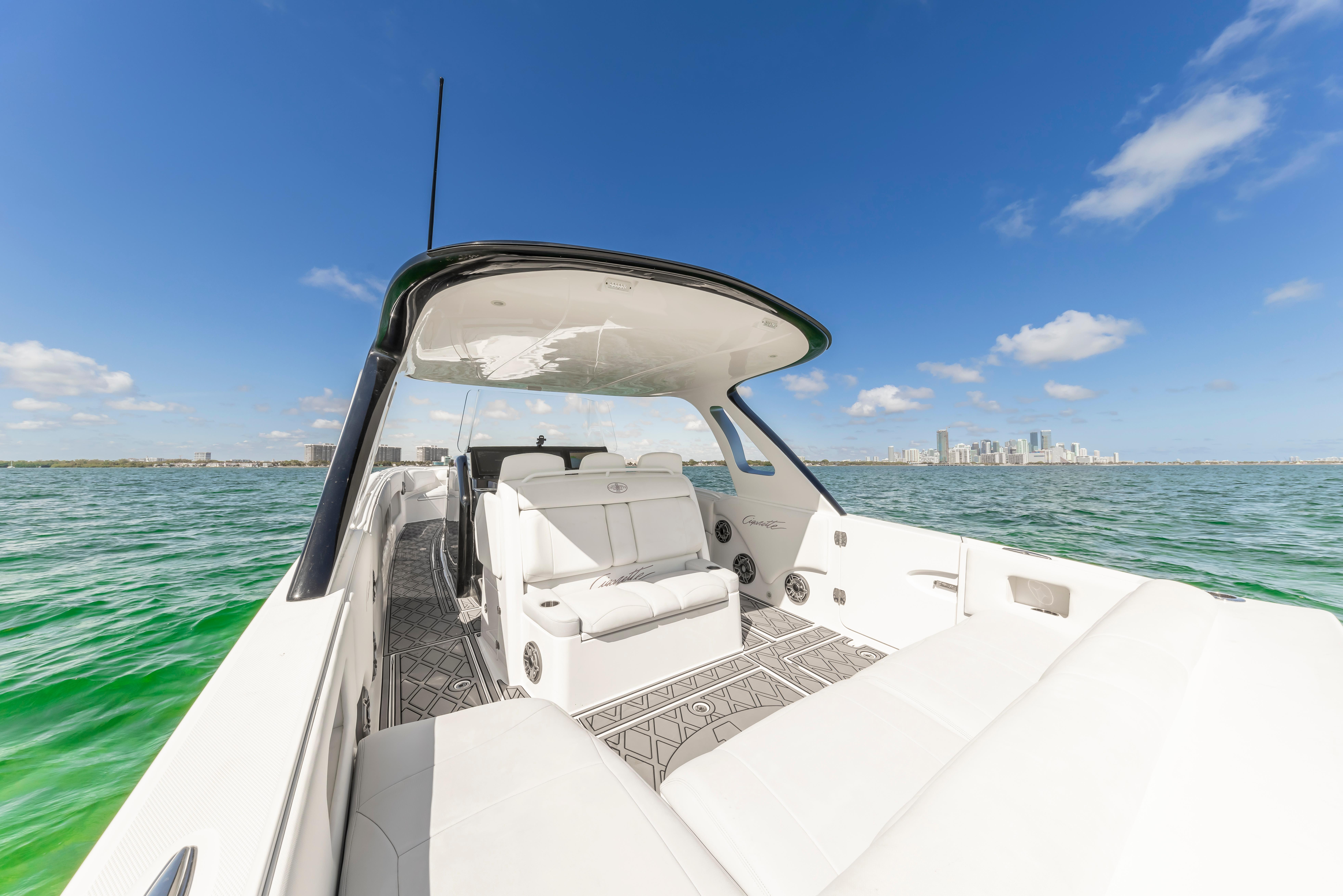 2016 Cigarette 41 GTR boat on clear water with city skyline in background.