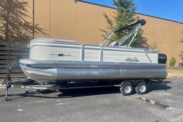 2026 Sun Tracker Party Barge 22 RF DLX pontoon boat on trailer, parked outdoors.