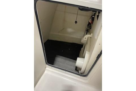 2022 Robalo R247 Dual Console interior storage compartment with black flooring.