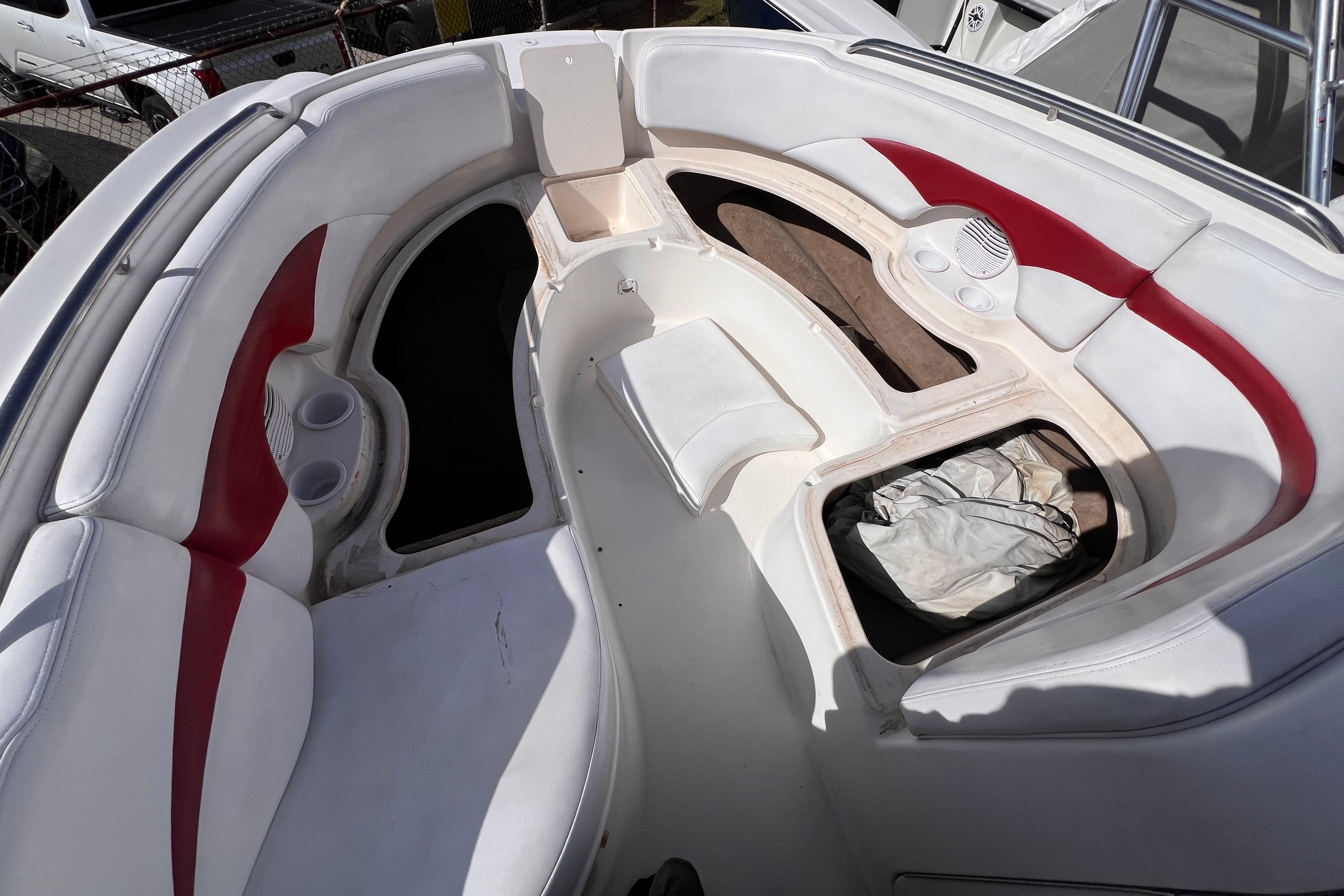 2002 Chaparral 232 Sunesta boat interior with white and red seating, storage compartments.