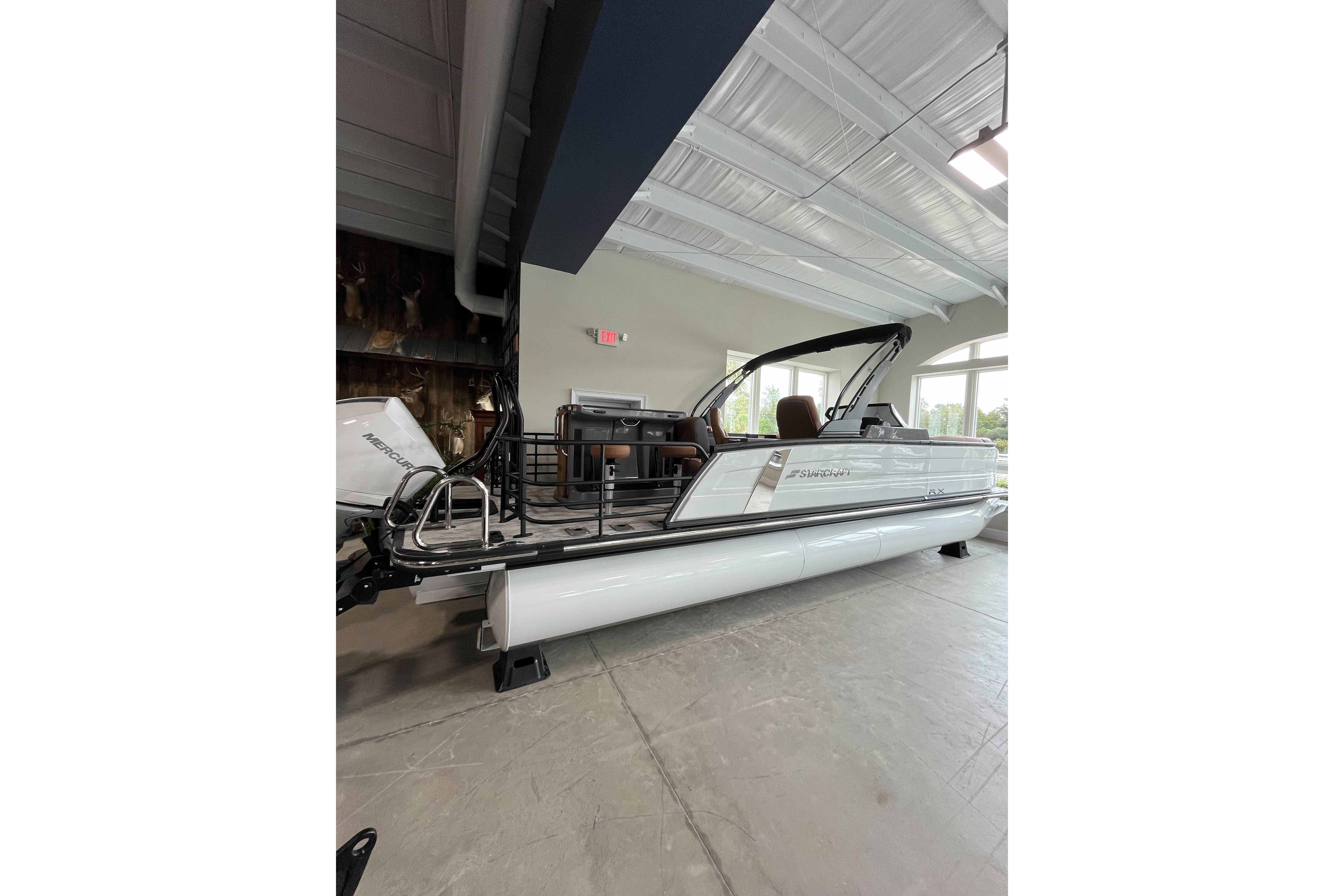 2026 Starcraft RX 25 DL DC pontoon boat displayed indoors, showcasing sleek design and modern features.