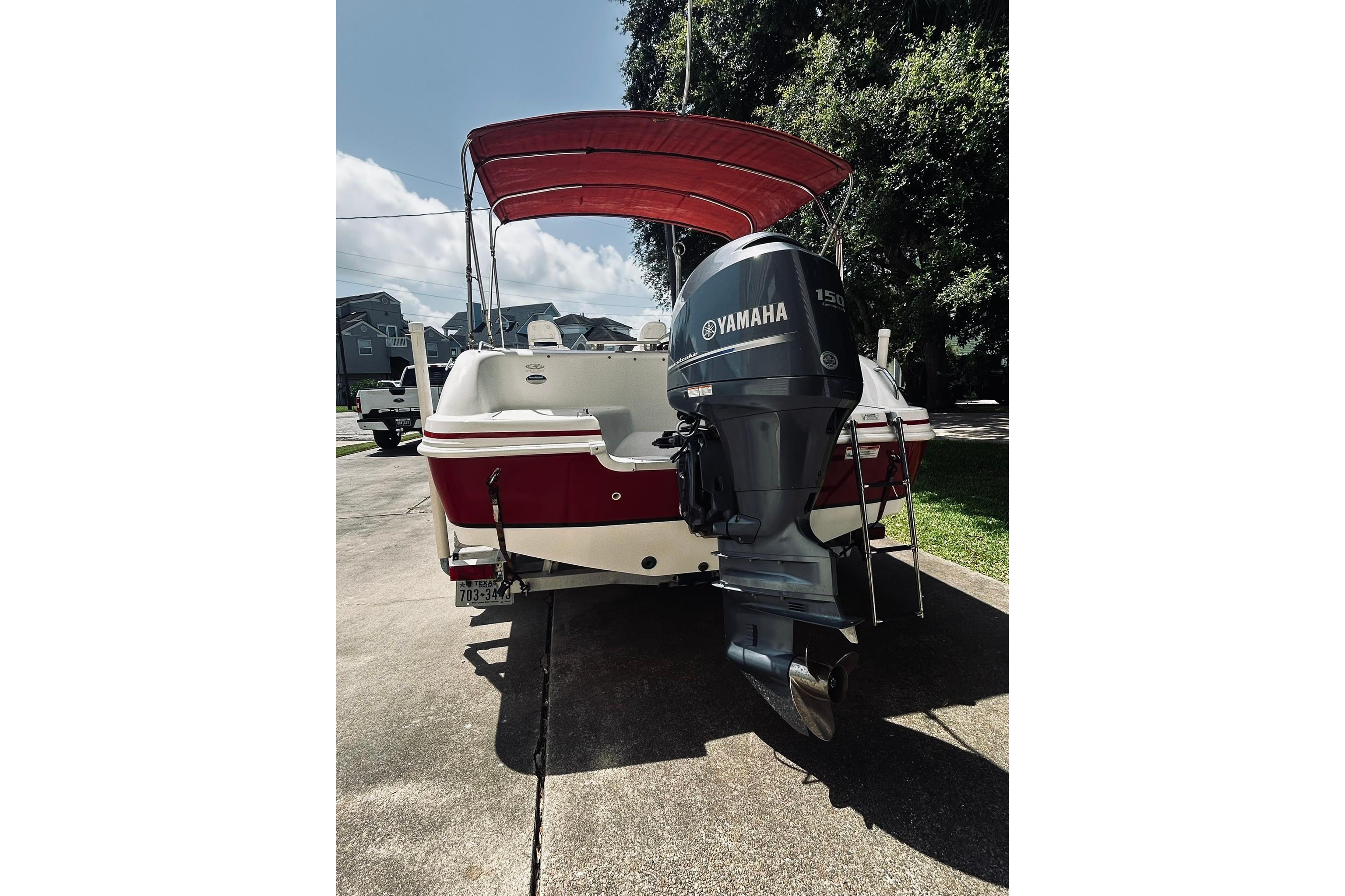 2013 Hurricane SunDeck Sport 201 OB boat with Yamaha outboard motor, parked on driveway.