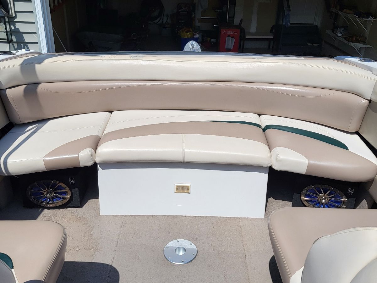 The image shows the seating area of a boat with beige and white upholstery.