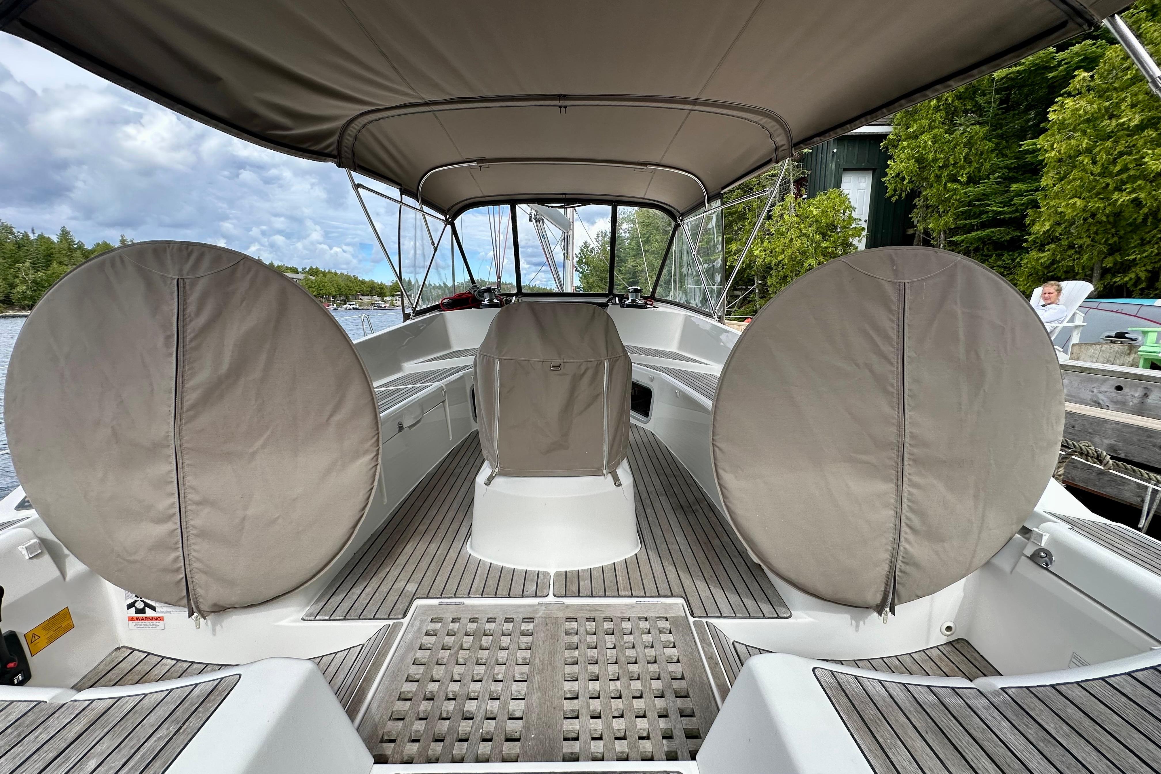 2015 Jeanneau Sun Odyssey 50 DS sailboat cockpit with covered steering wheels and canopy.
