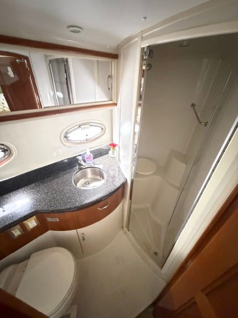 The image shows a yacht bathroom with a sink, toilet, and shower.