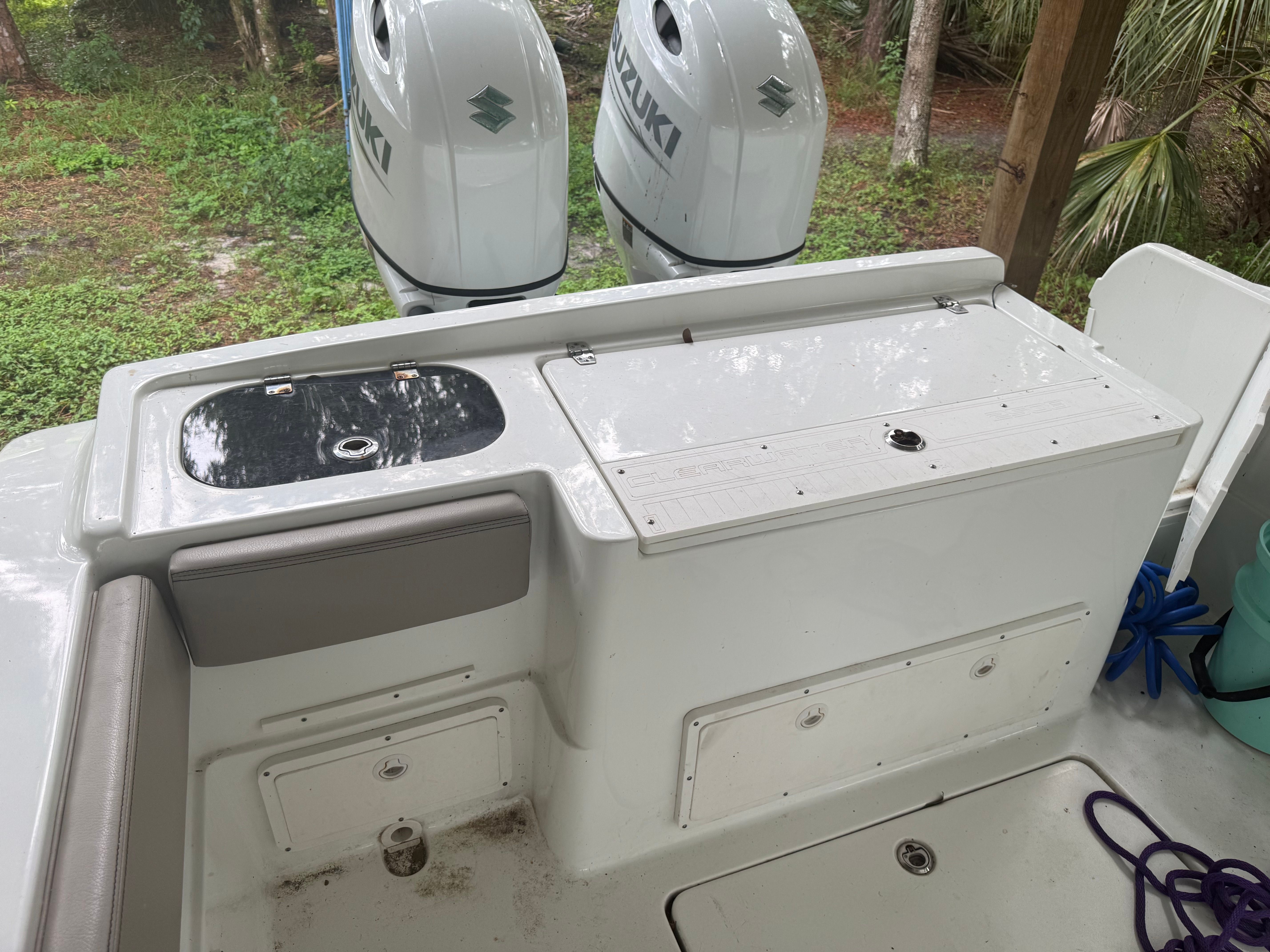The image shows the stern of a Clearwater 2508 Center Console boat with two Suzuki engines.