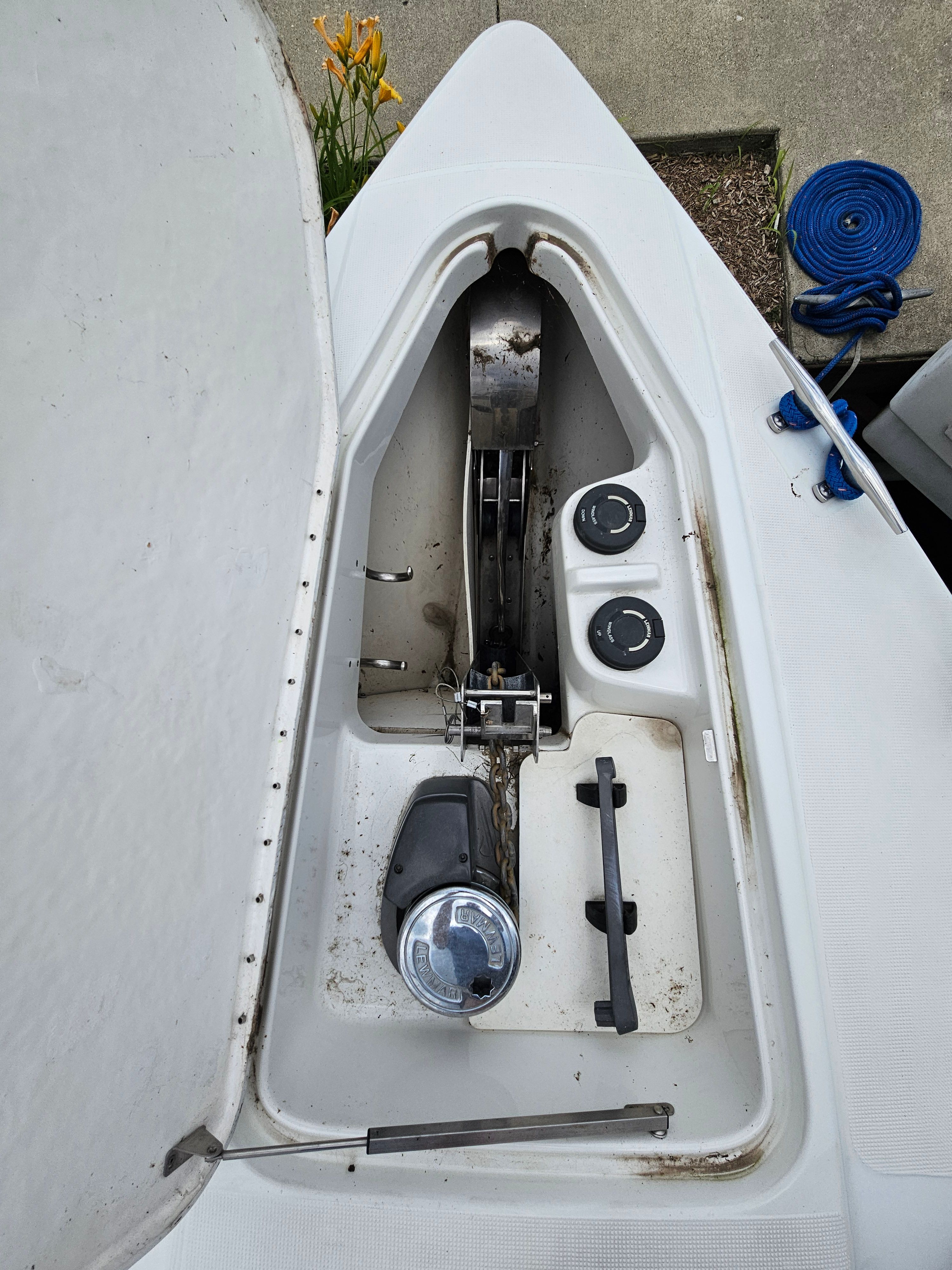 Boat anchor locker with windlass and rope.