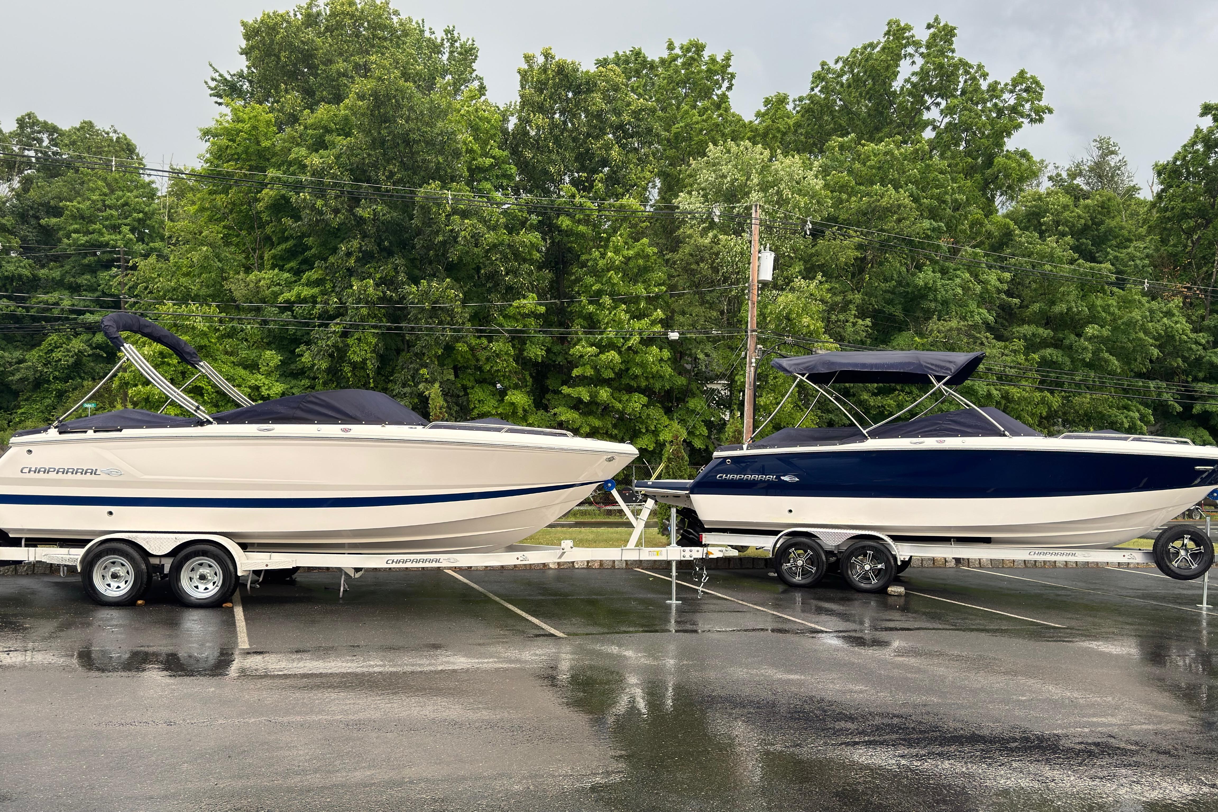 2026 Chaparral SSX 4 boats on trailers in a parking lot, surrounded by trees.