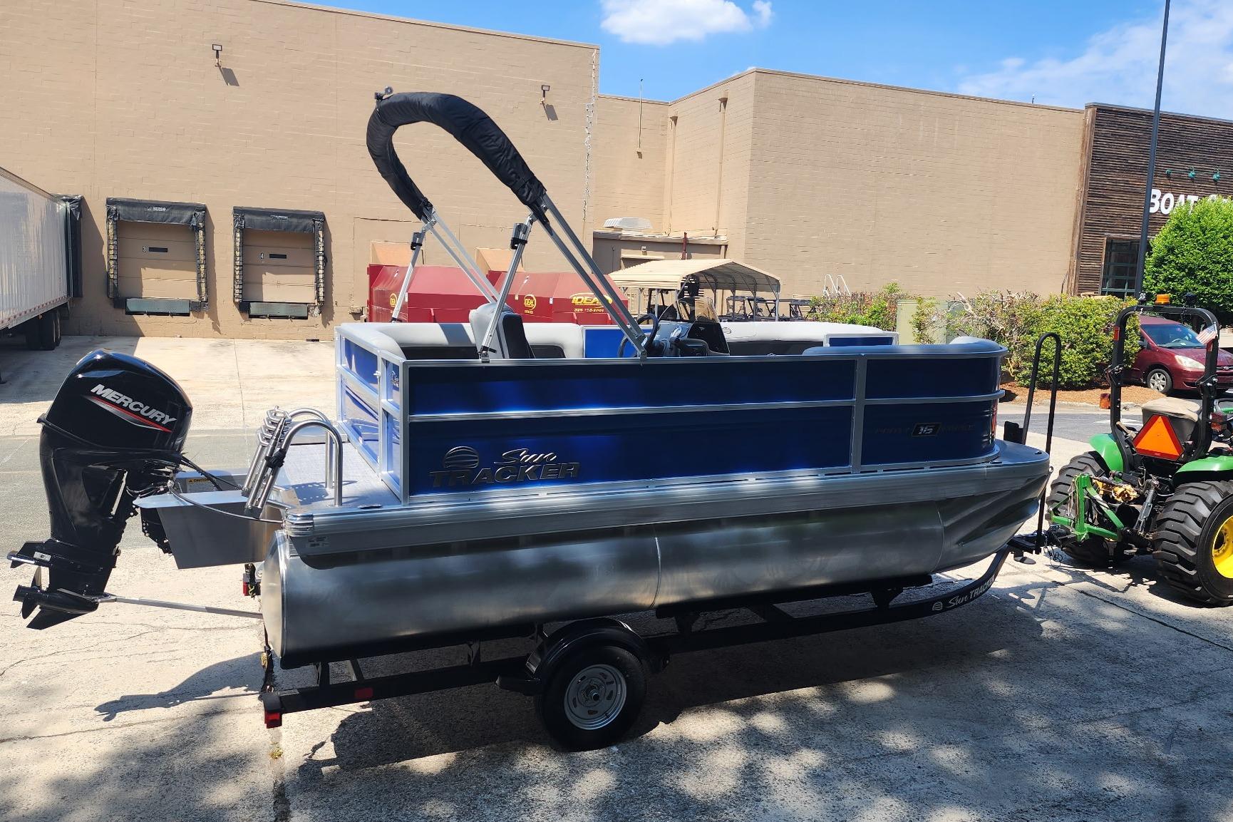 2026 Sun Tracker Party Barge 16 DLX pontoon boat with Mercury outboard motor on trailer.