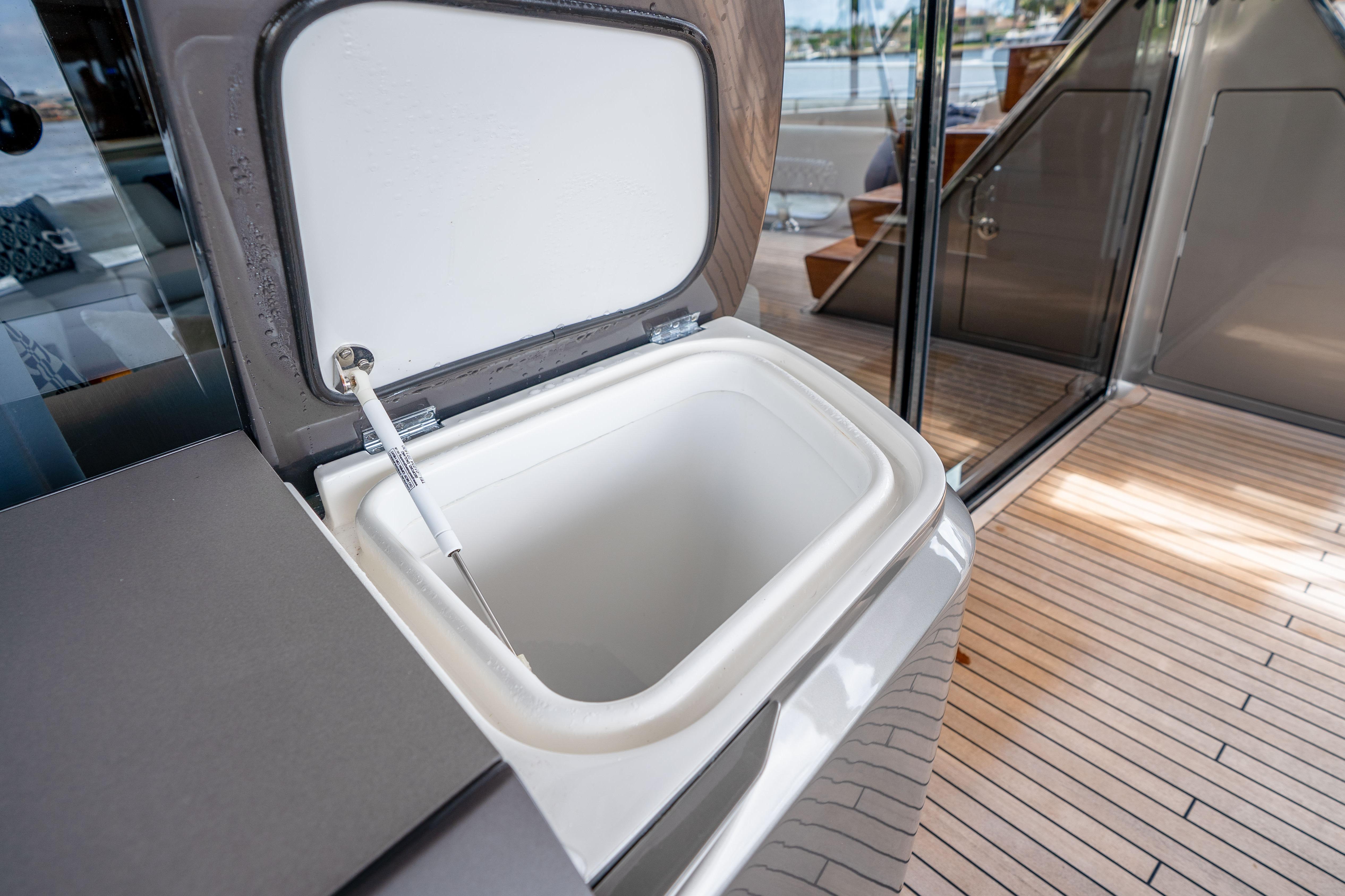 Open storage compartment on 2020 Princess Y85 yacht deck with wooden flooring.