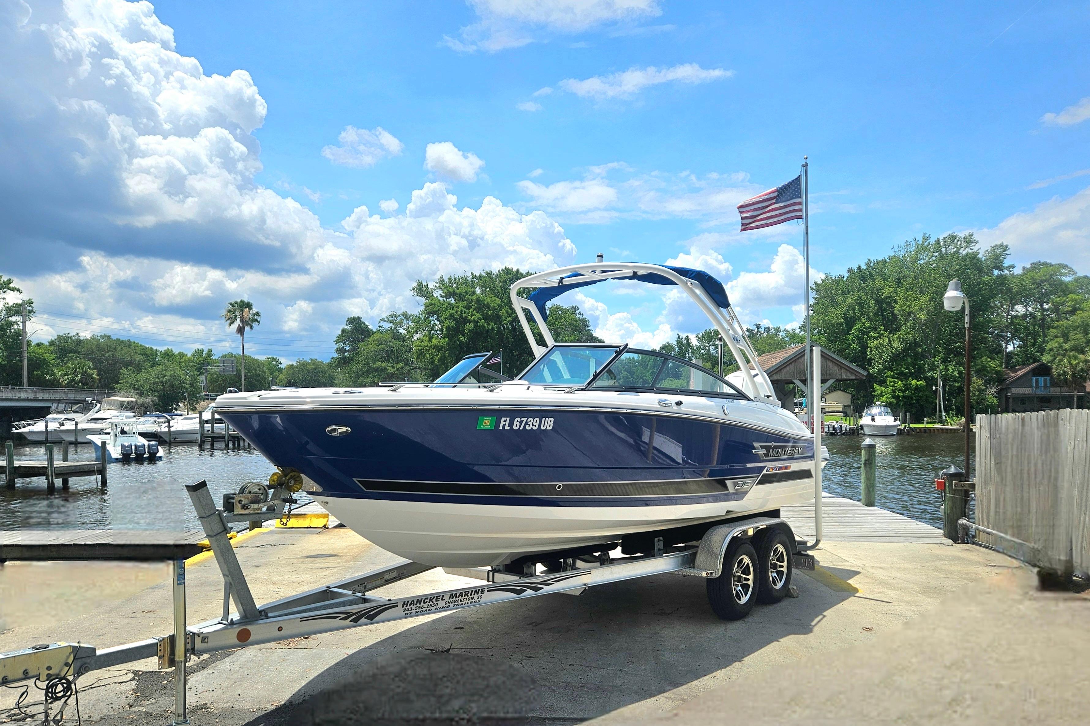 2024 Monterey 215SS Super Sport boat on trailer by waterfront, under blue sky.