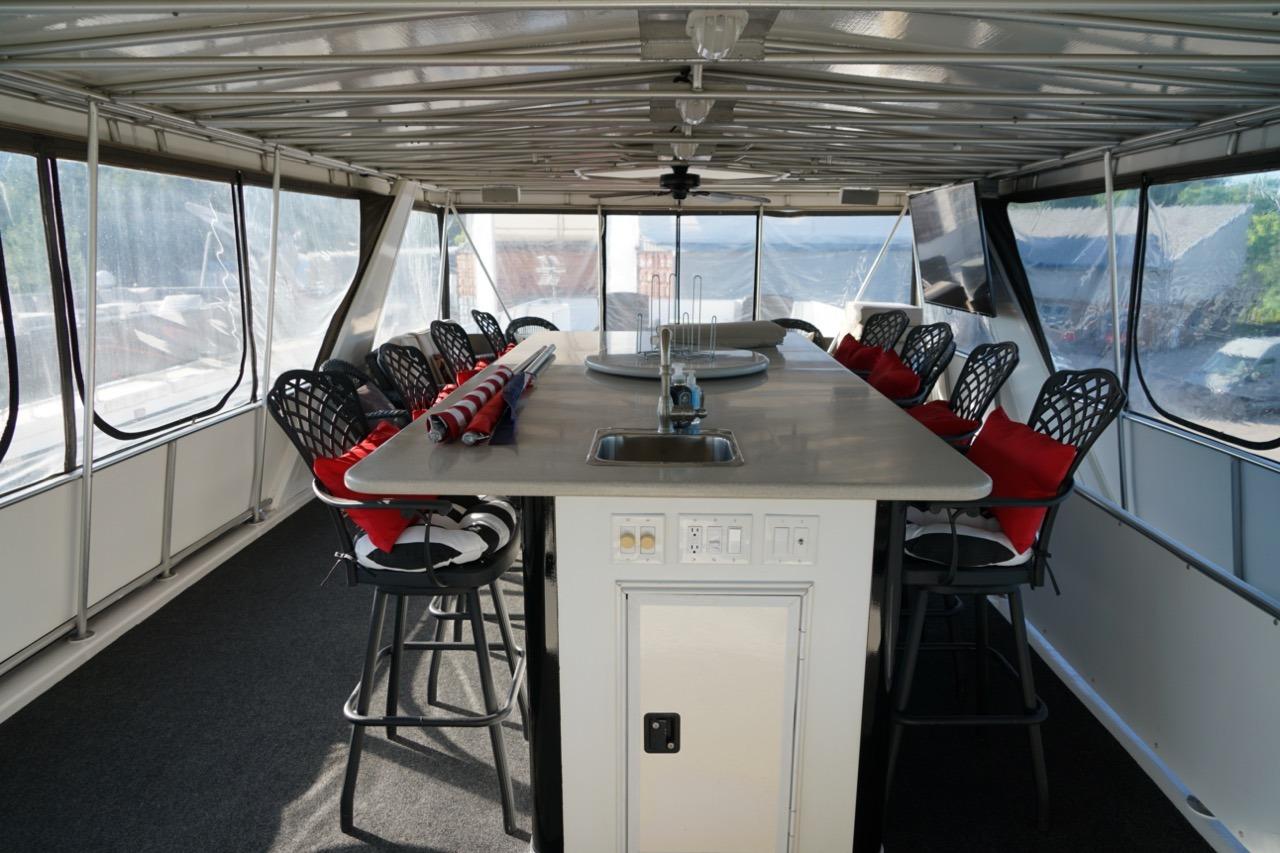 Interior of 2000 Stardust Cruisers houseboat with bar seating and panoramic windows.