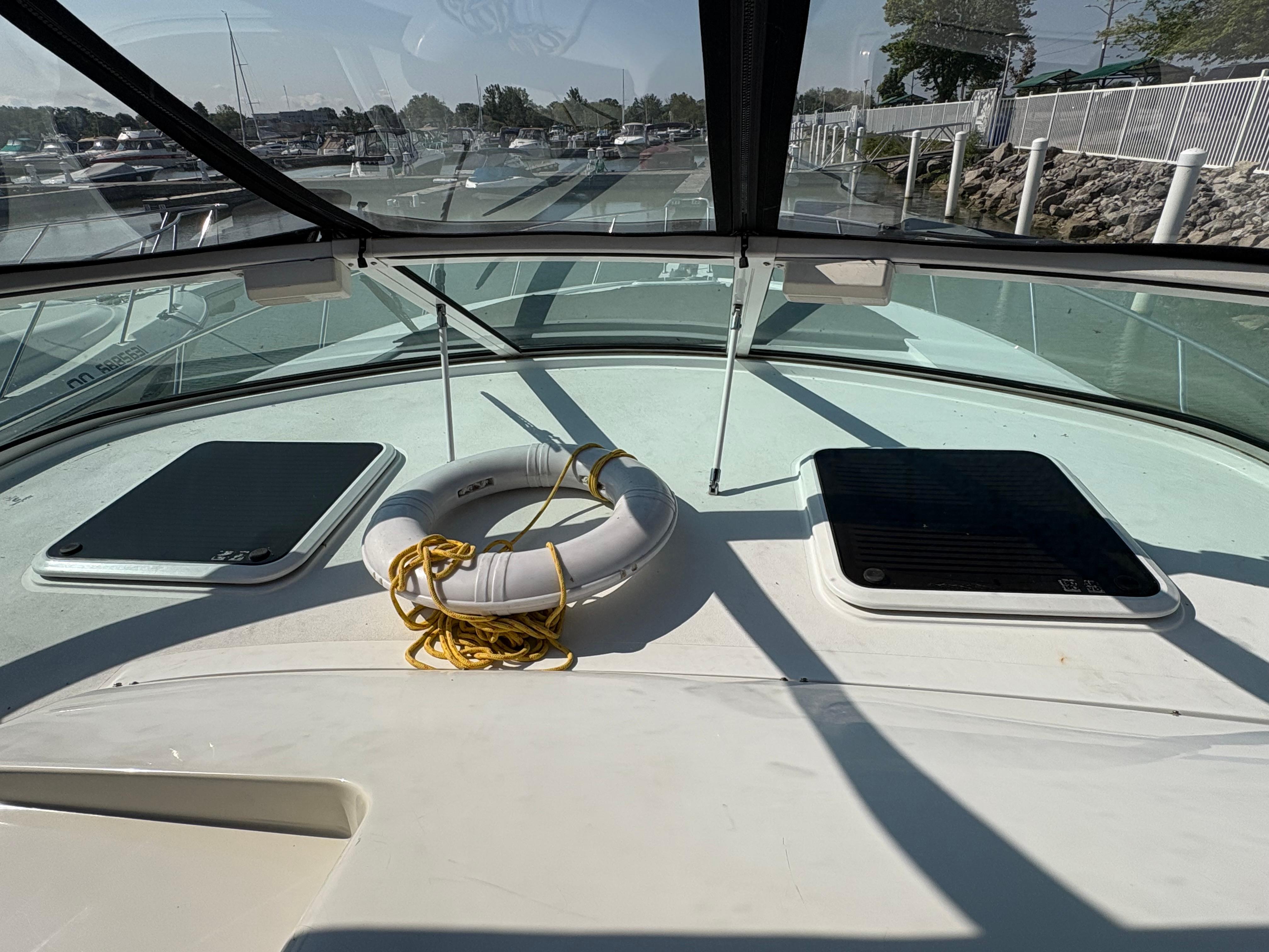 2000 Trojan 40 Express Cruiser deck with life ring and hatches, docked at marina.