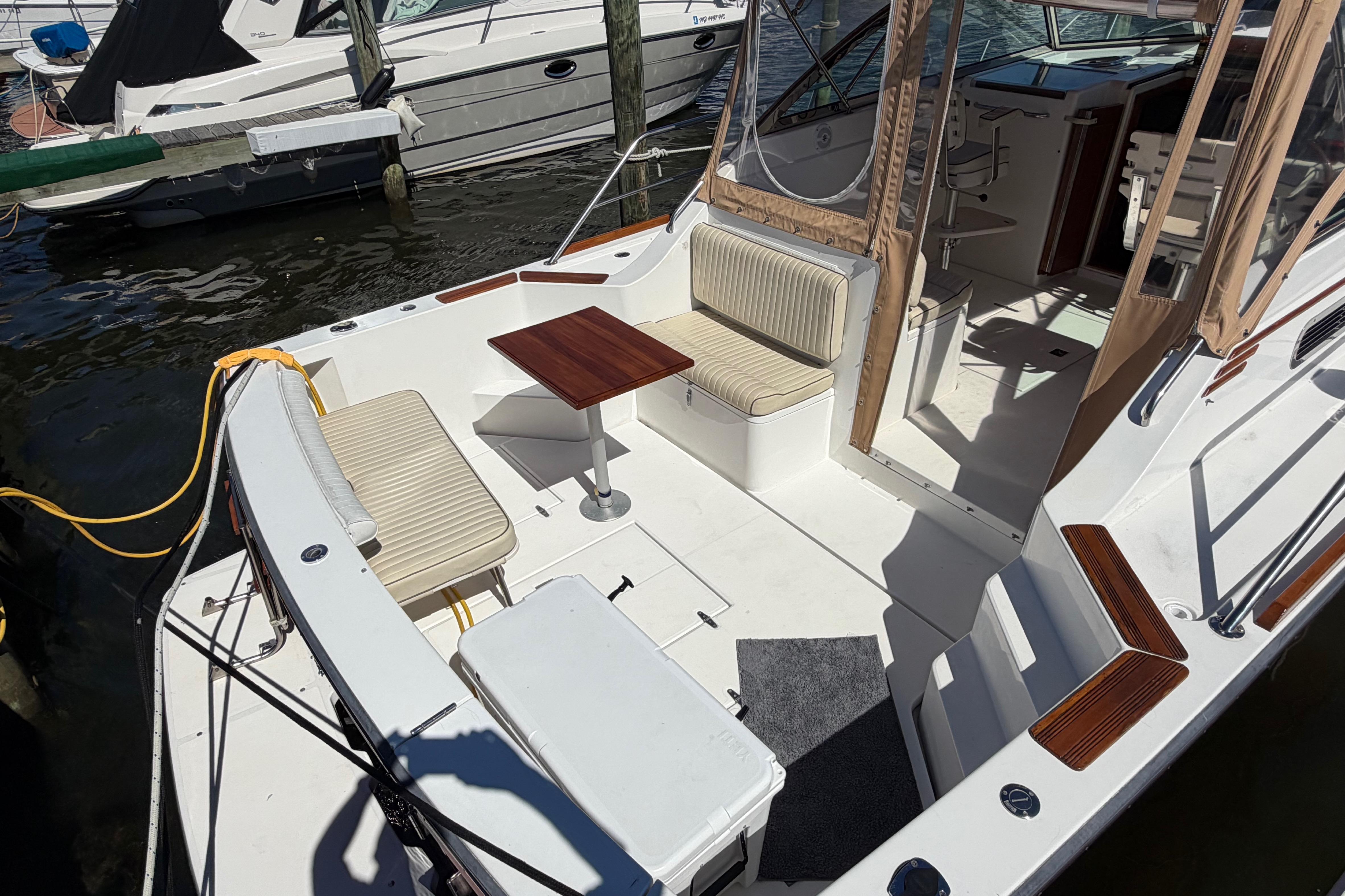 2000 Sabreline 36 Express boat interior with seating and table in a marina.