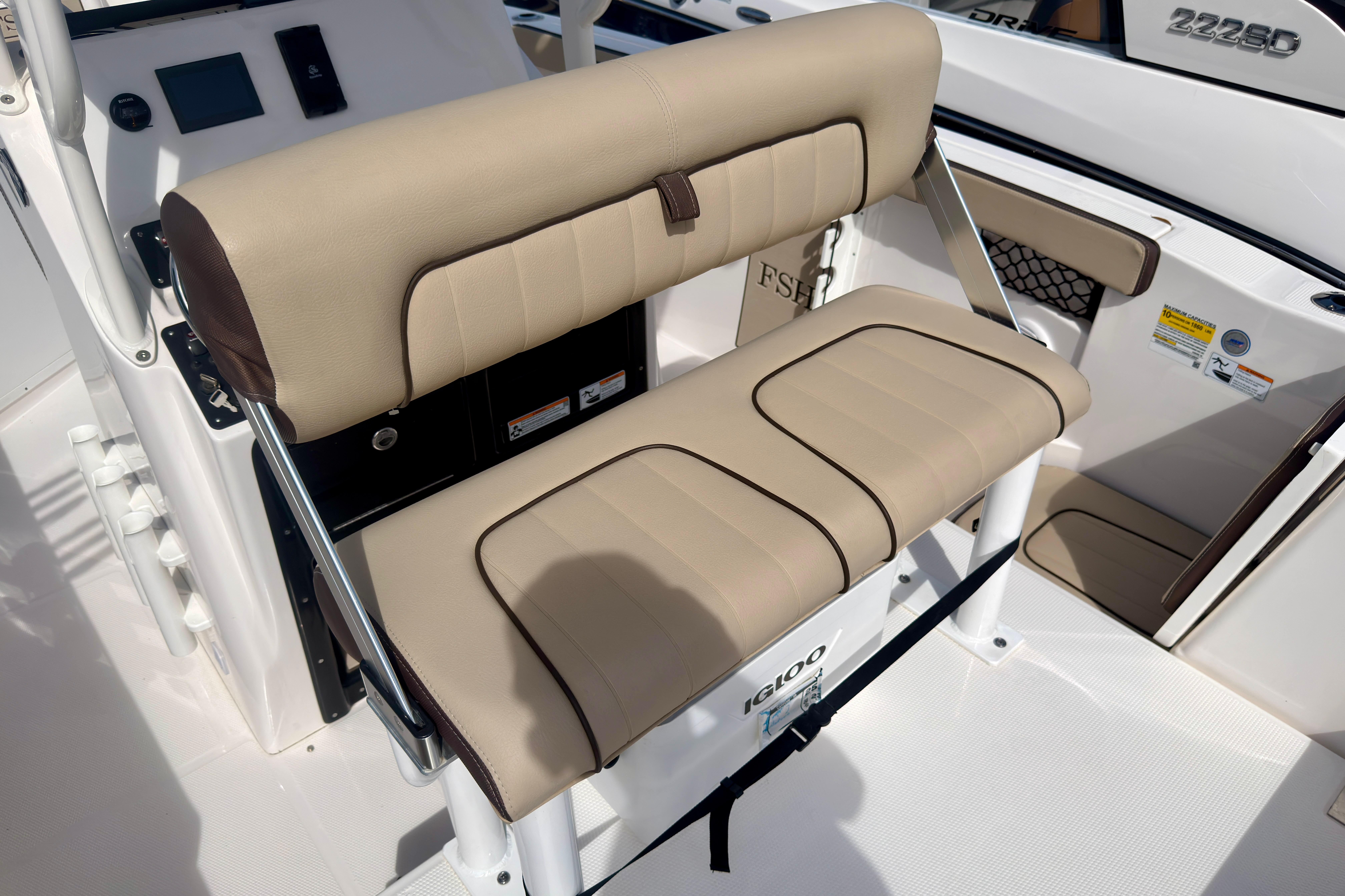 2025 Yamaha Boats 222 FSH Sport interior seating with beige upholstery and Igloo cooler.