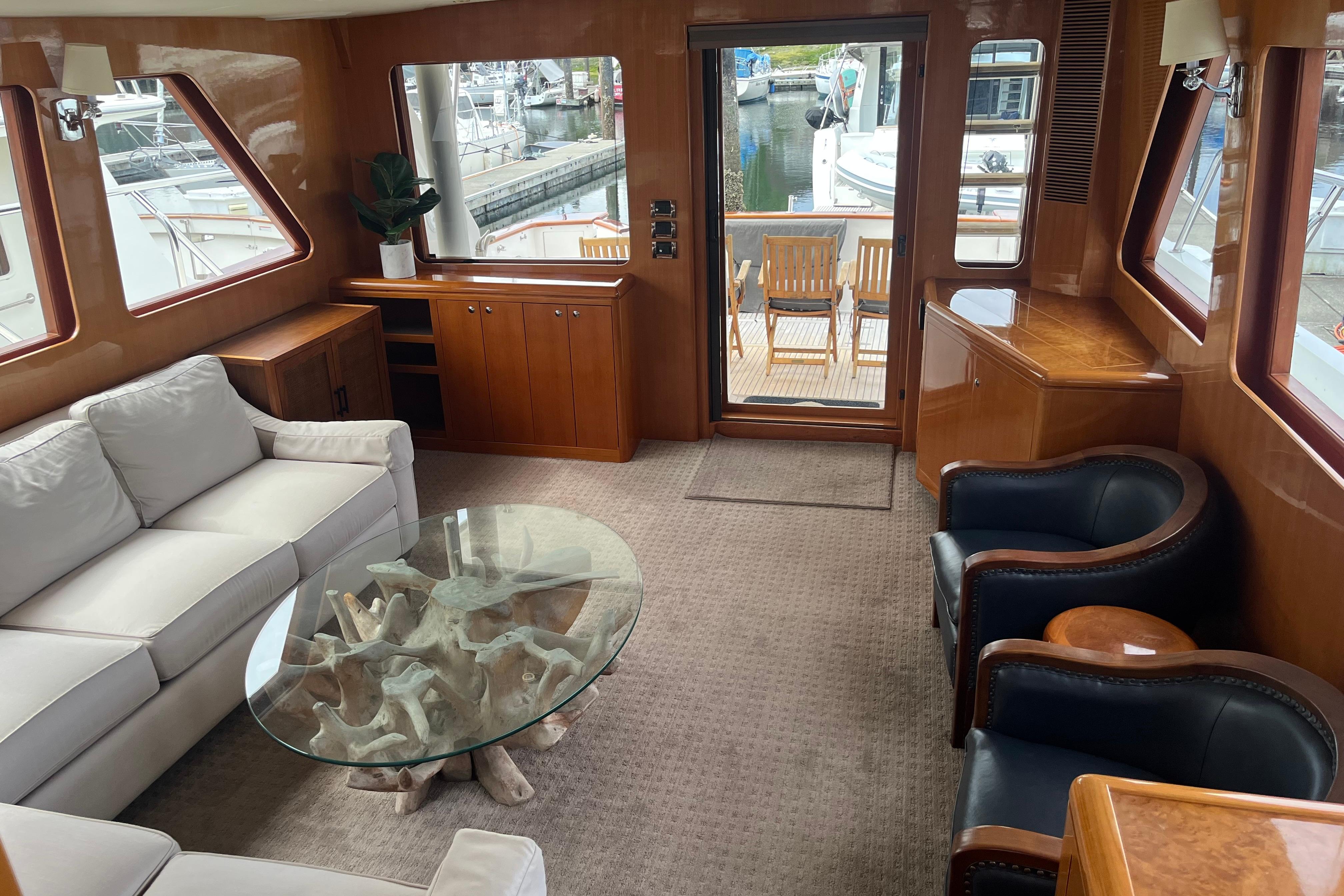 Luxurious interior of 2004 Ocean Alexander 64 Pilothouse yacht with elegant seating and glass table.