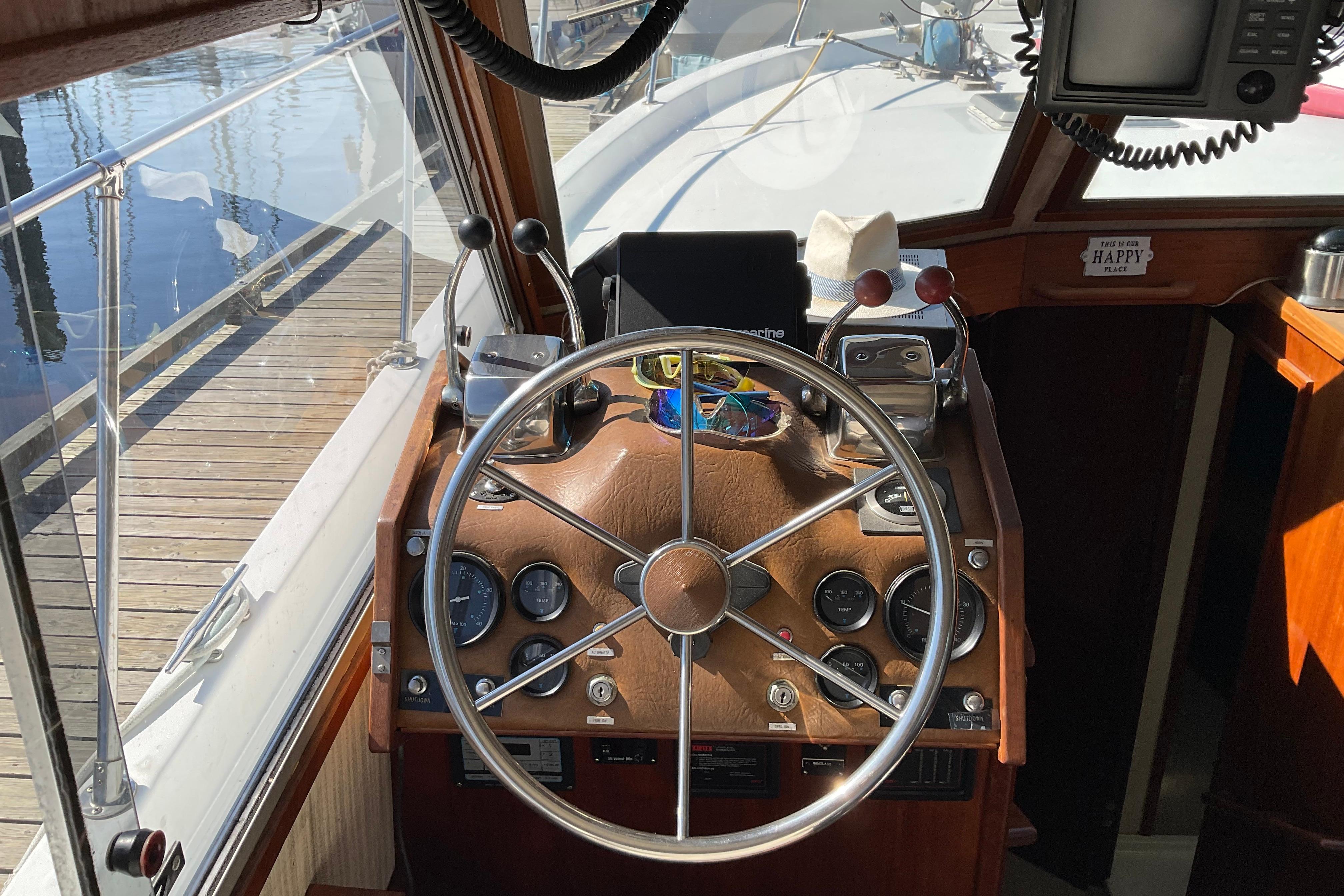 1980 Unflite Coastal Cruiser helm with steering wheel and control panel.
