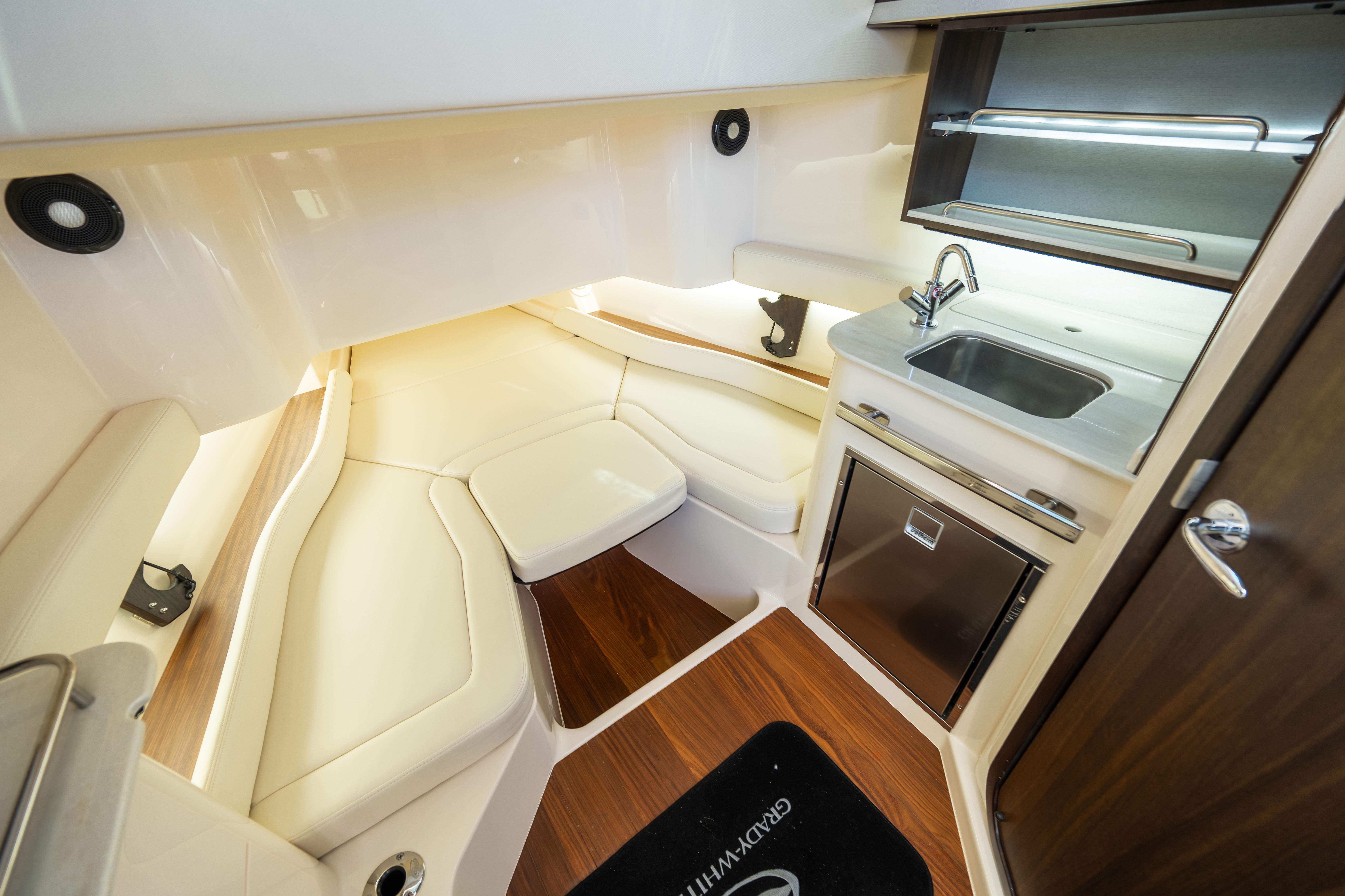Luxurious interior of 2025 Grady-White Canyon 386 boat with kitchenette and seating area.